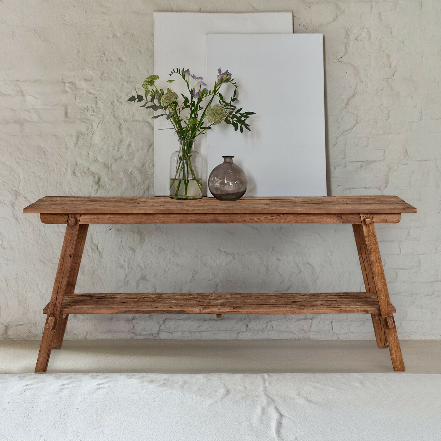 Wandtafel Brévonne Houten tafel in natuurlijke kleur met plank en vazen met bloemen voor witte muur