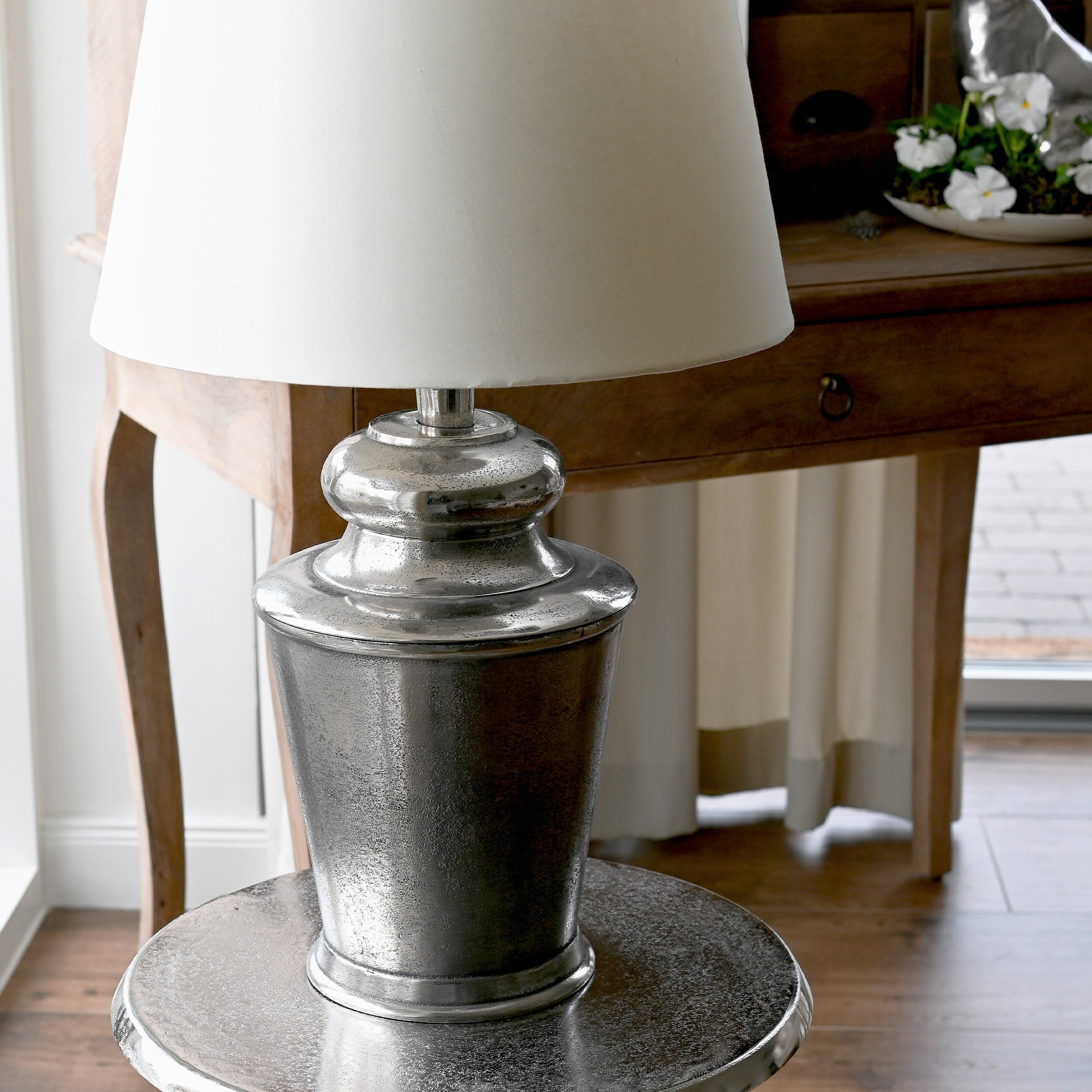 Tafellamp met zilveren metalen voet en witte kap, vintage interieurdecoratie