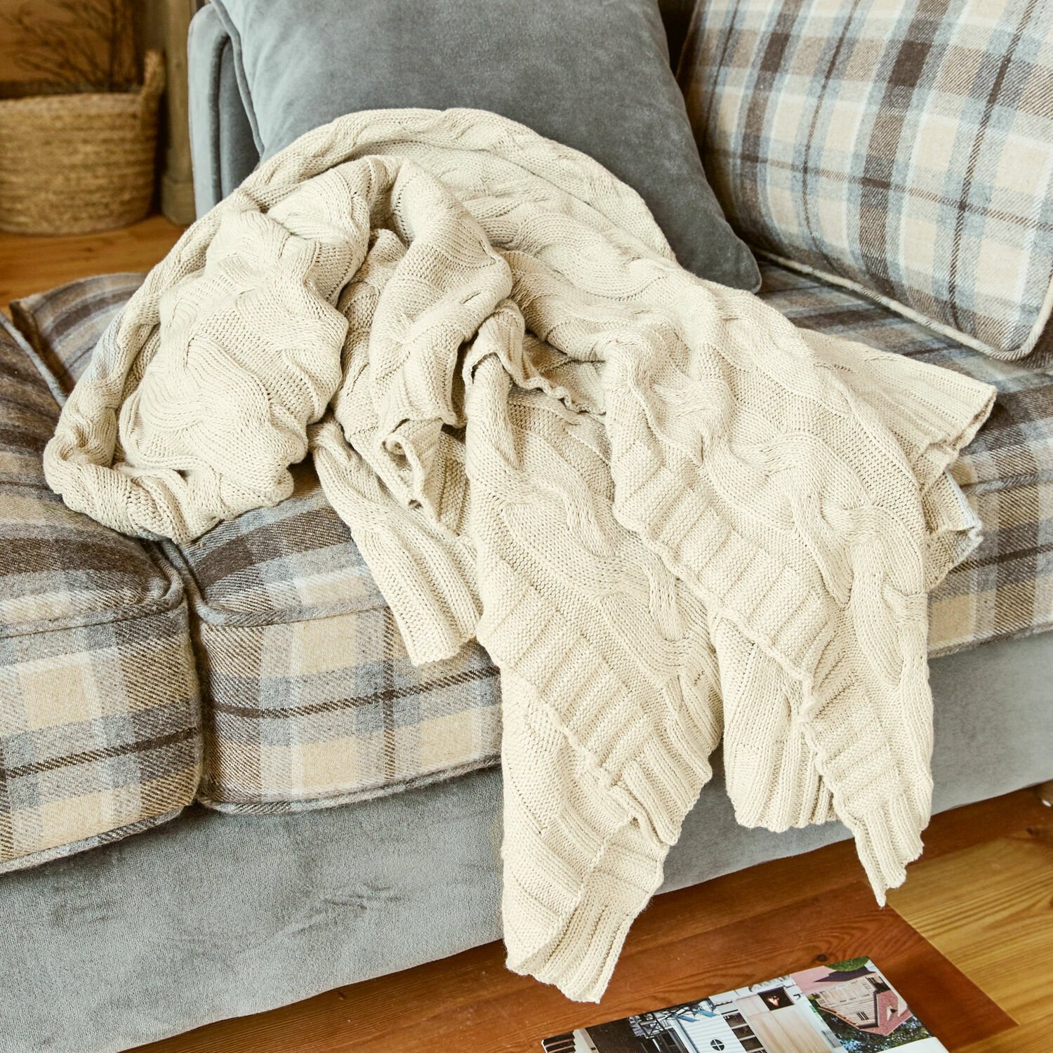 Plaid Arnhem Beige gebreide katoenen deken op grijze bank met beige ruitpatroon in woonkamer