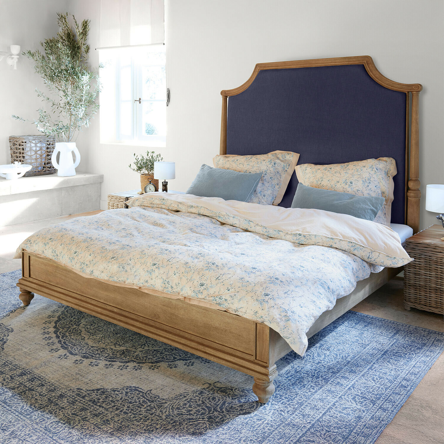 Bed Fairmontine Houten bed met donkerblauw gestoffeerd hoofdeinde in lichte slaapkamer met blauw tapijt