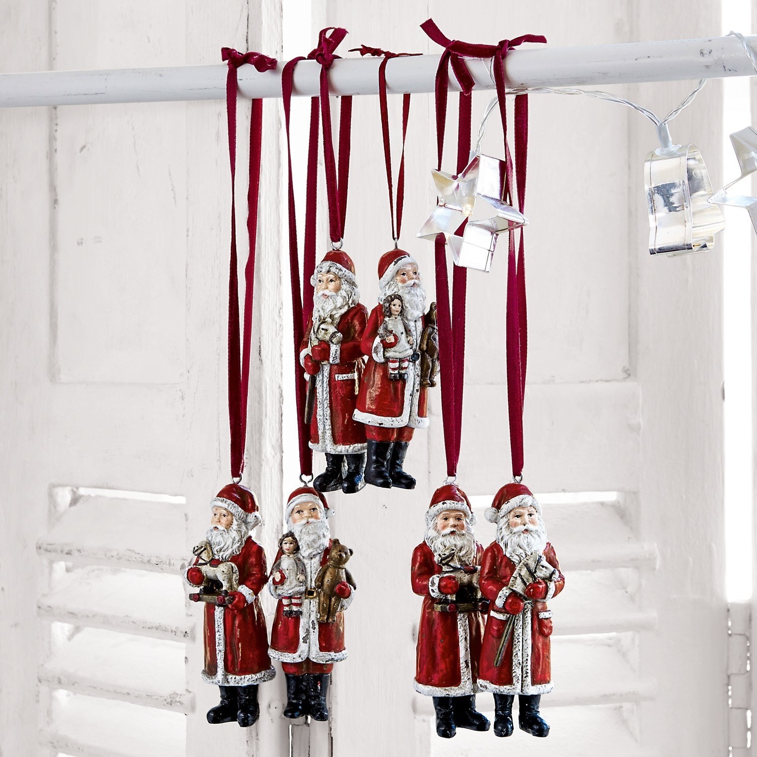 Set rode kerstmanversieringen van materiaal hangend aan bordeauxrode linten, kerstdecoratie