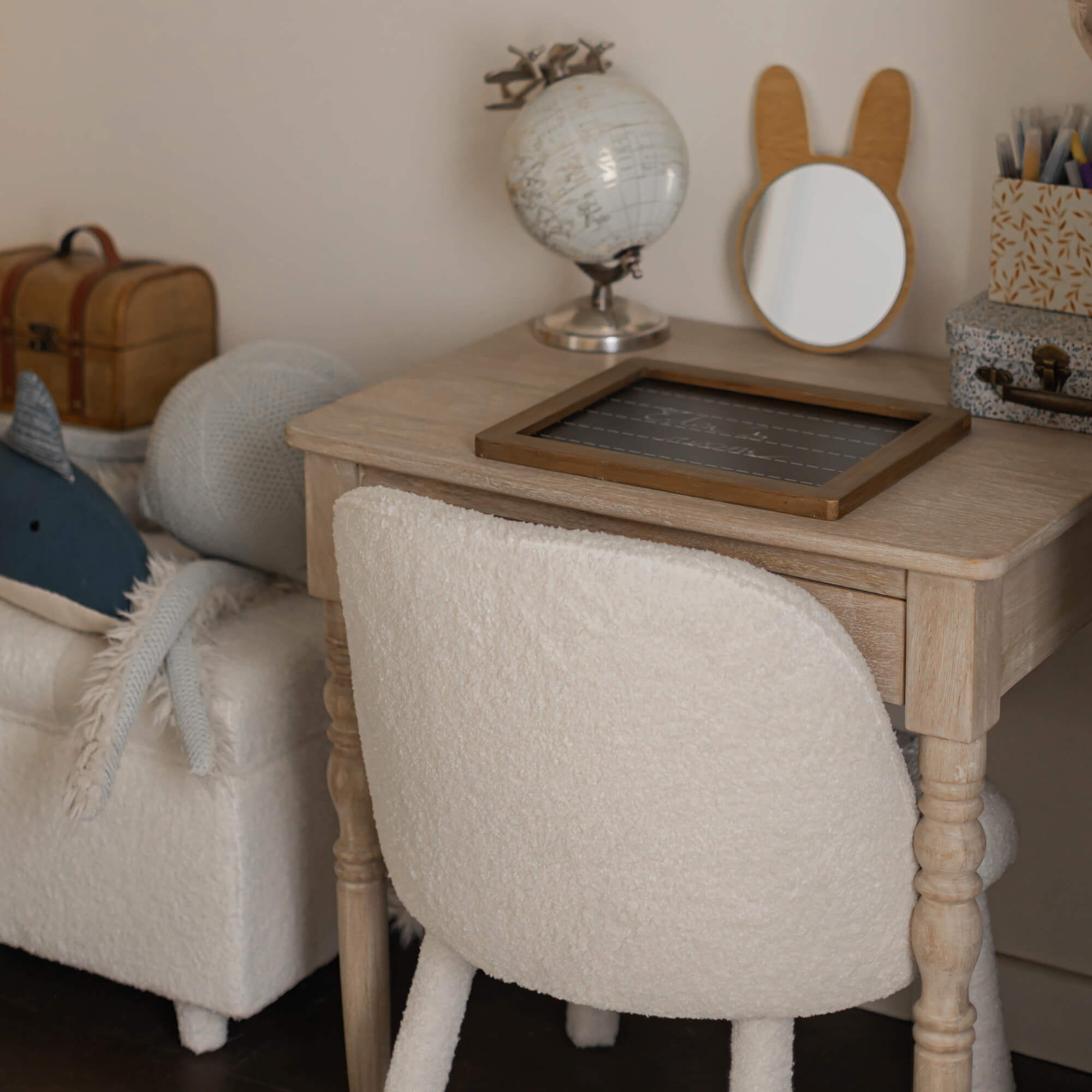 Licht houten bureau met beige zachte stoffen stoel in een gezellige kinderkamer