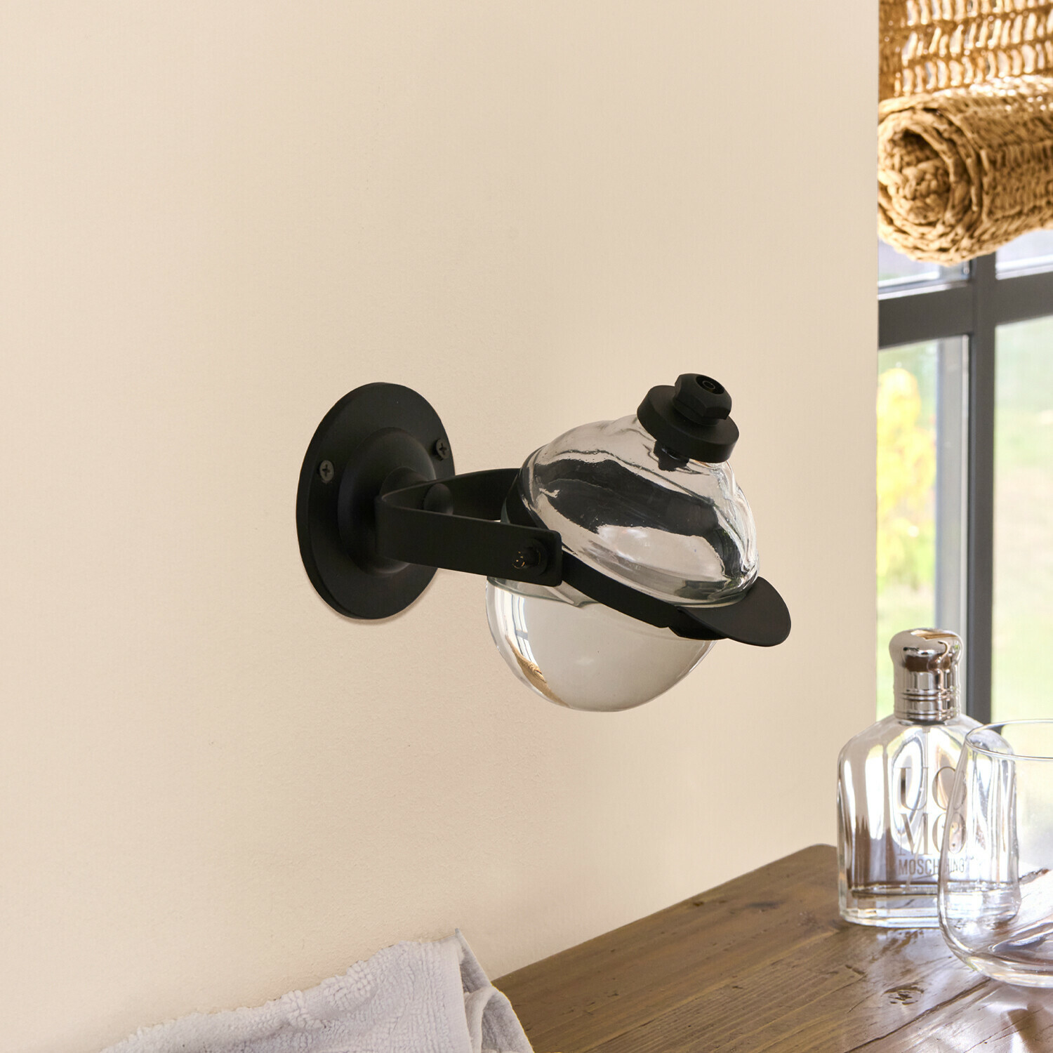 Zwarte metalen wandhouder met doorzichtige glazen zeepdispenser voor badkamer