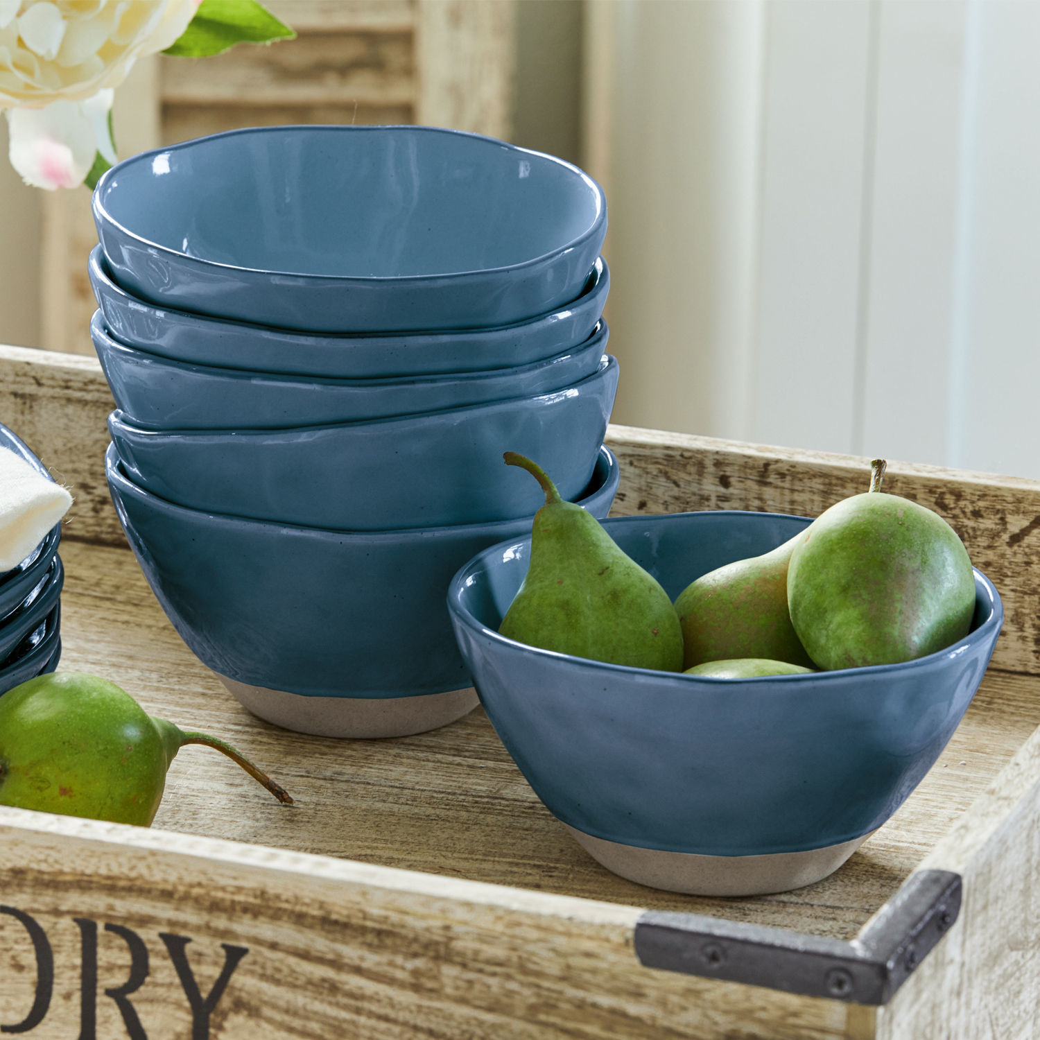 Set blauwe keramische kommen met natuurlijke bodem op houten dienblad met peren