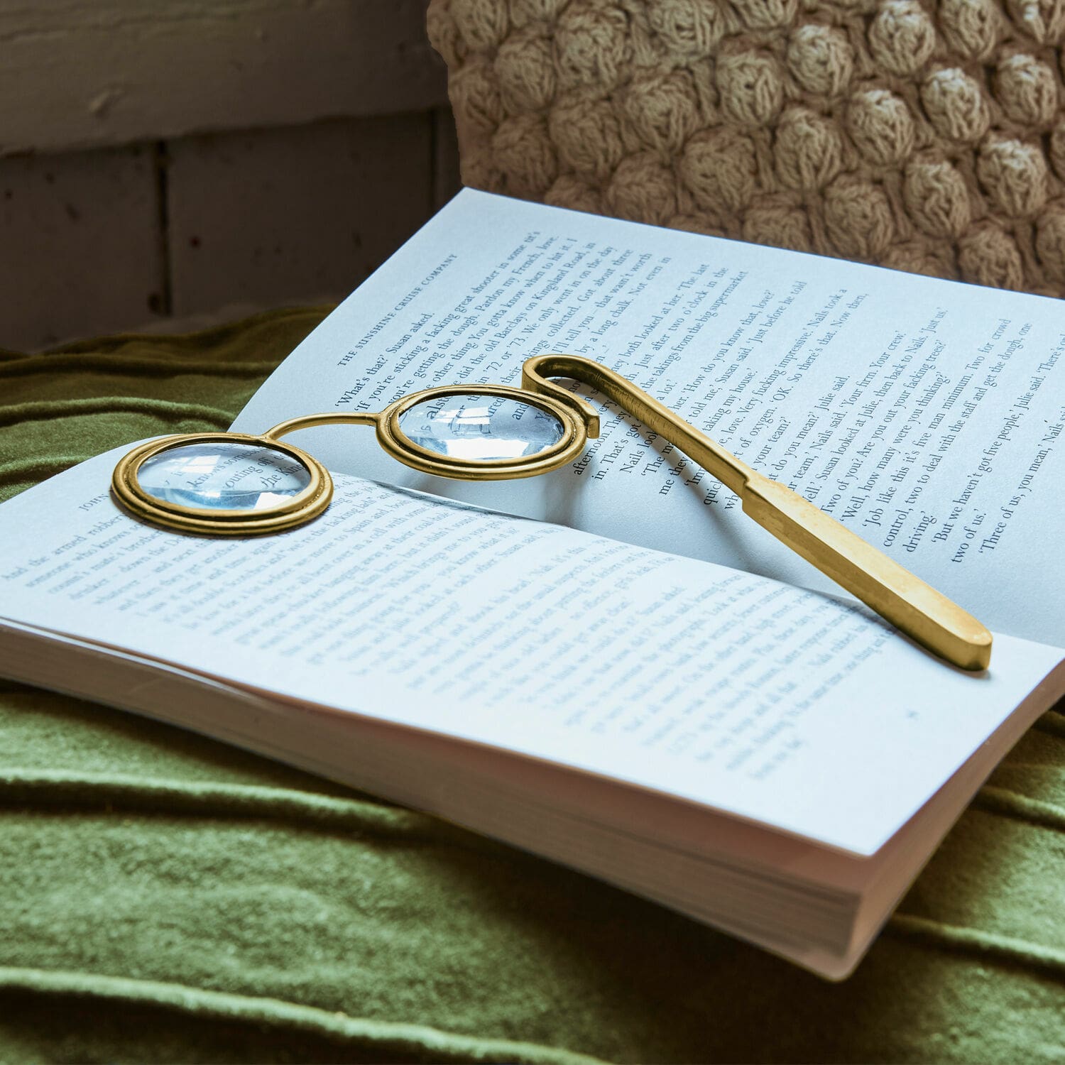 Loep Robert Gouden leesbril met ronde glazen op een open boek op groene stof