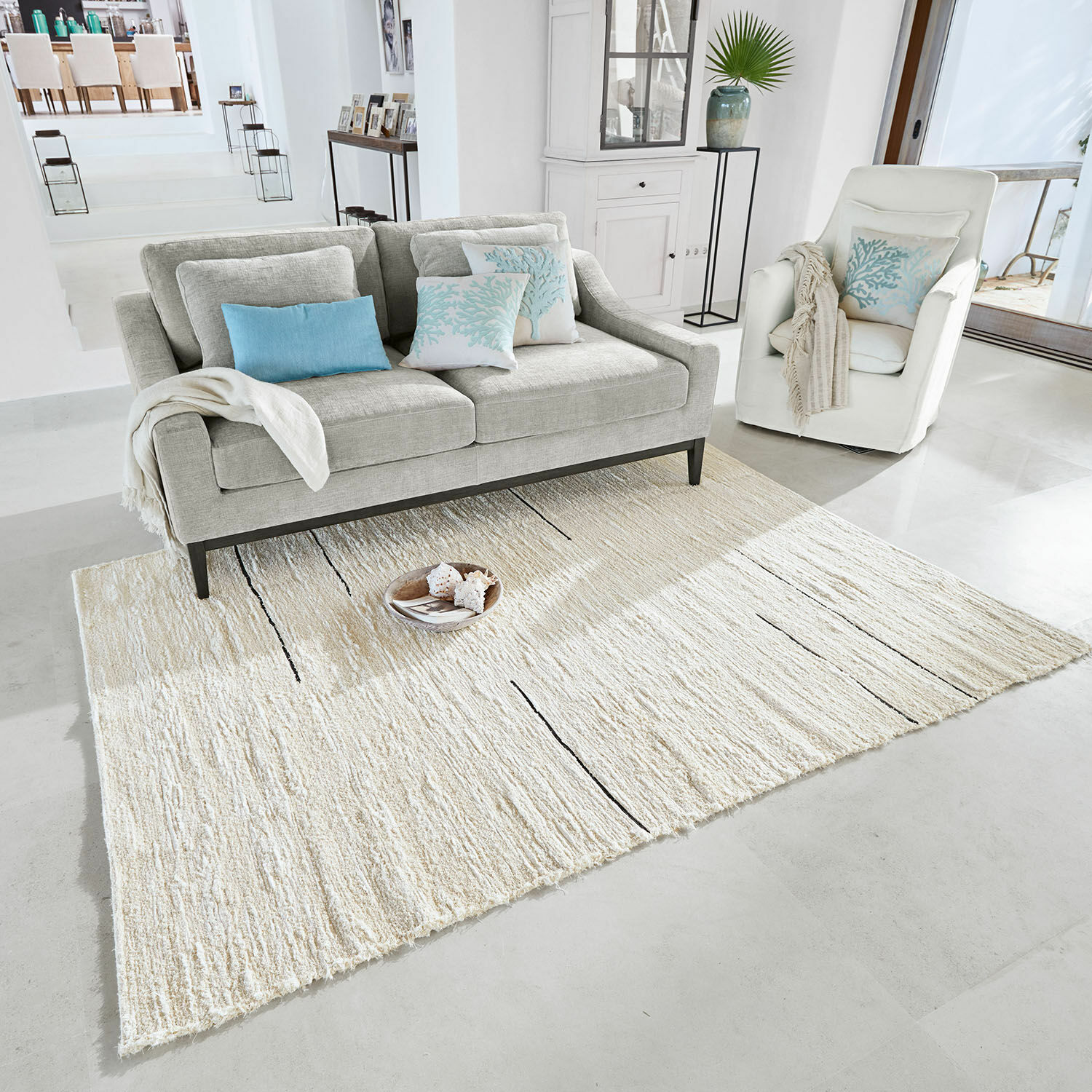 Vloerkleed Avatele Lichtgrijs vloerkleed met subtiel patroon in moderne woonkamer met bank en fauteuil