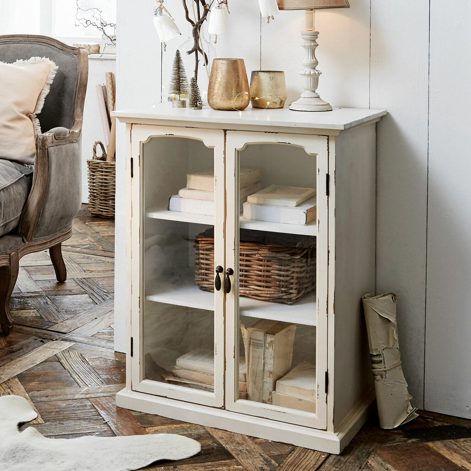 Witte houten kast met glazen deuren en planken vol boeken, vintage stijl