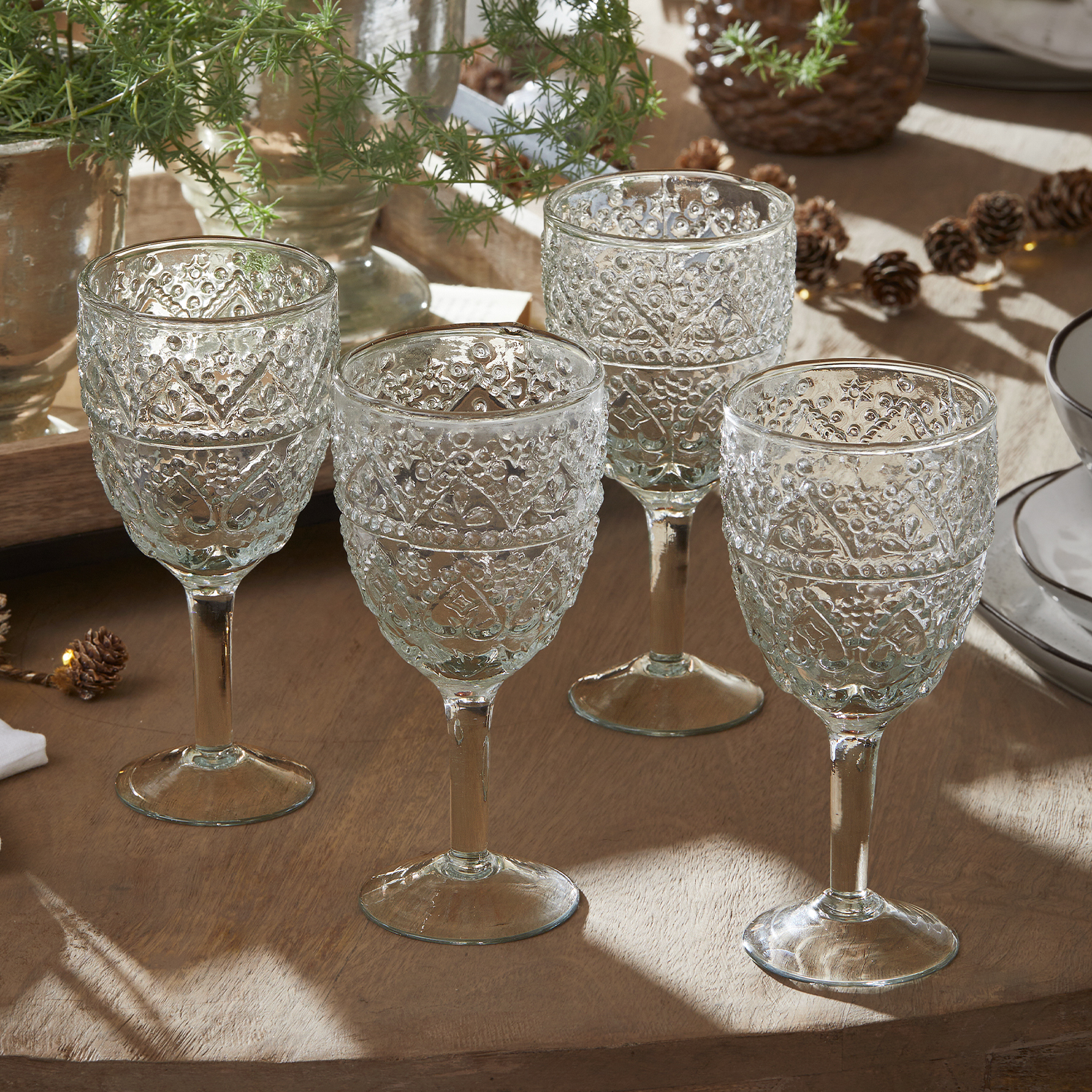 Set van vier transparante glazen met decoratief patroon op houten tafel voor het serveren van dranken