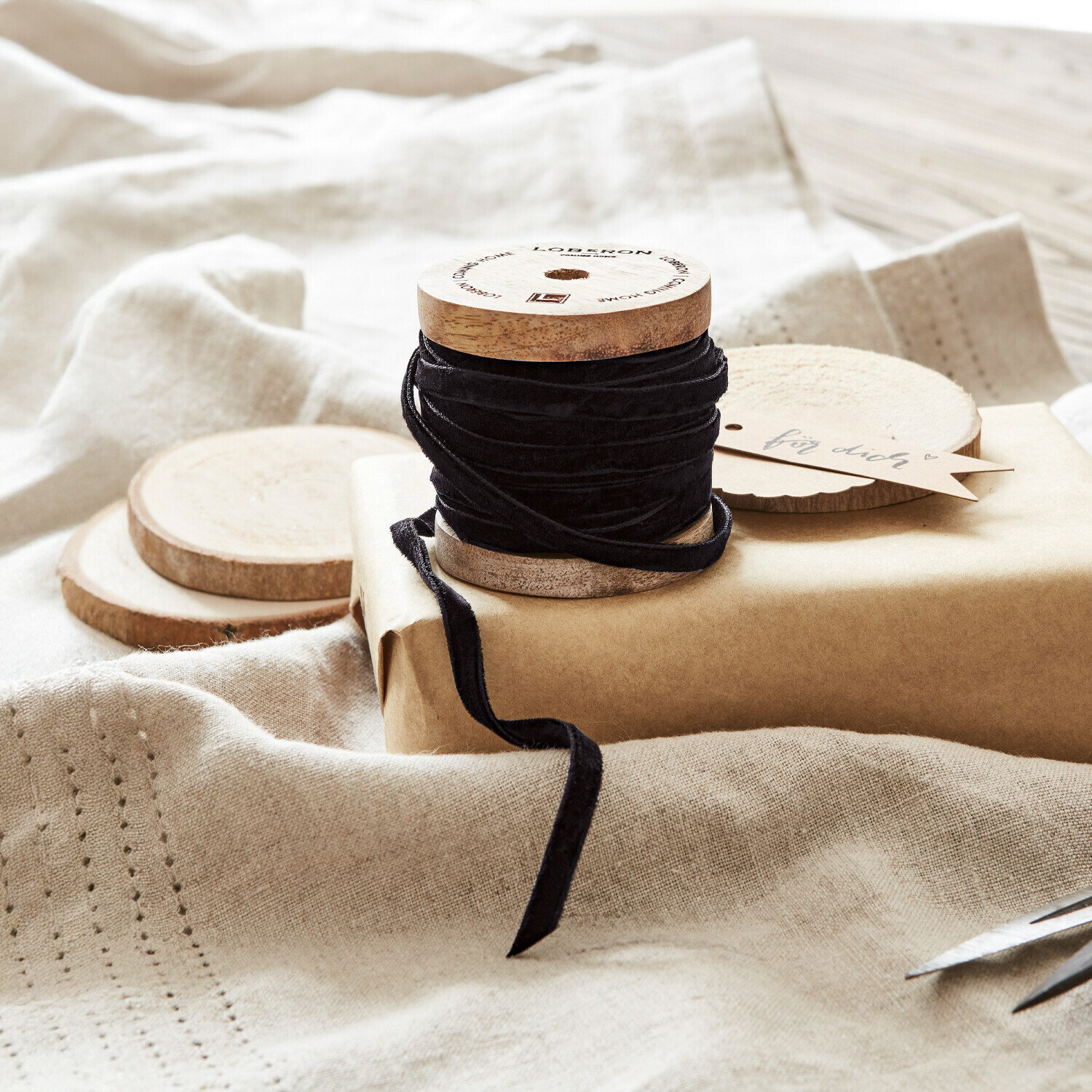 Fluwelen lint Olessa Zwarte fluwelen lint op houten spoel met natuurlijk kraftpapier en schaar voor cadeauverpakking