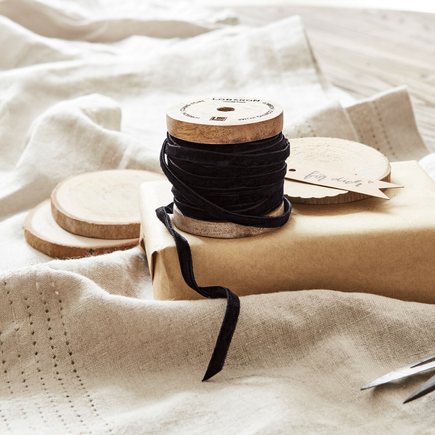 Fluwelen lint Olessa Zwarte fluwelen lint op houten spoel met natuurlijk kraftpapier en schaar voor cadeauverpakking