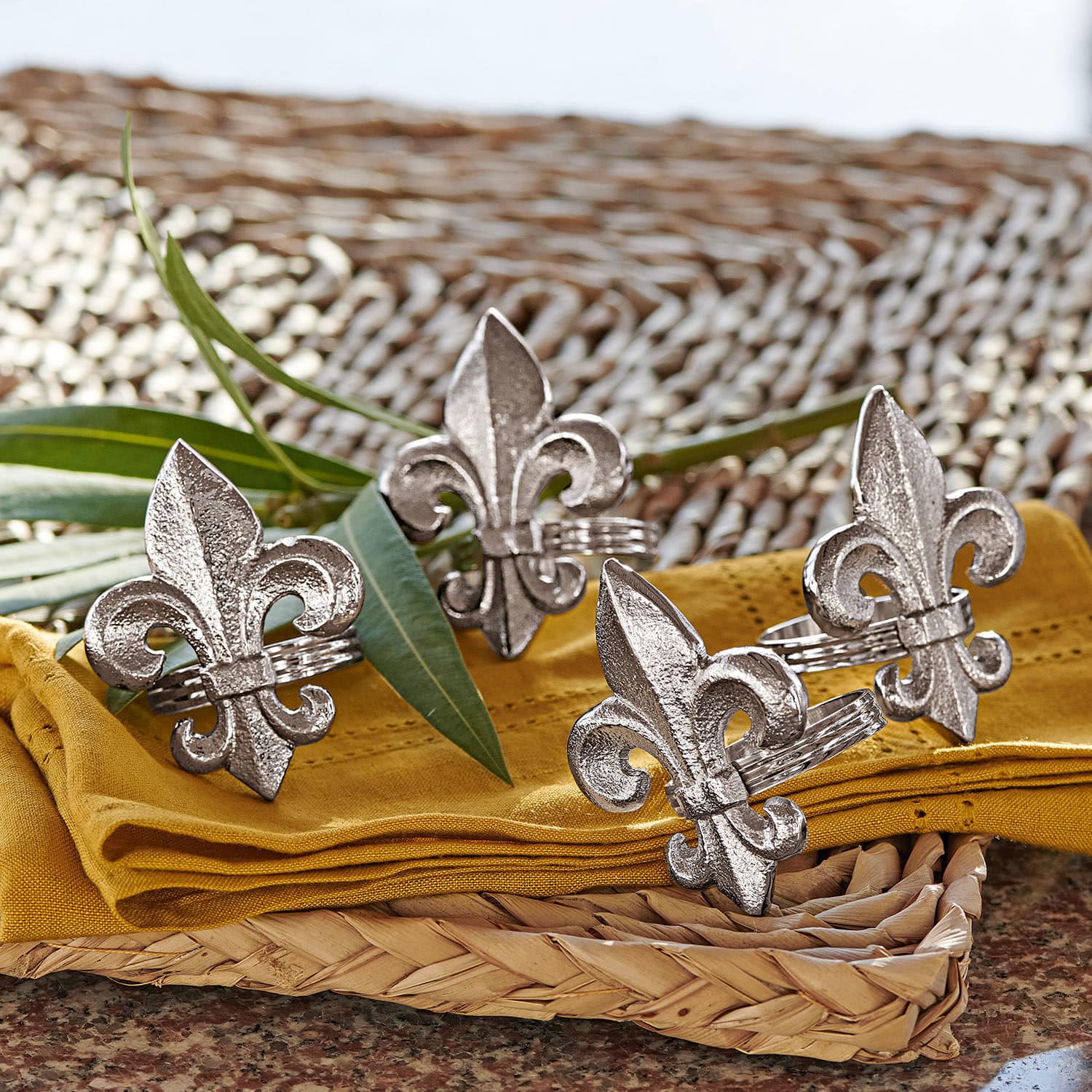 Servetring set van 4 Fleur De Lis Zilverkleurige metalen servetringen met lelie-motief op gele stof en gevlochten dienblad