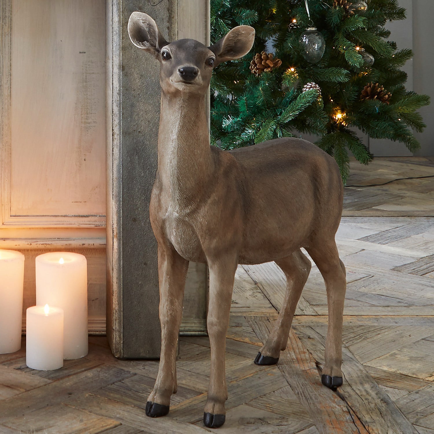 Ree Ruud Bruine decoratieve hertenfiguur bij verlichte kerstboom en kaarsen