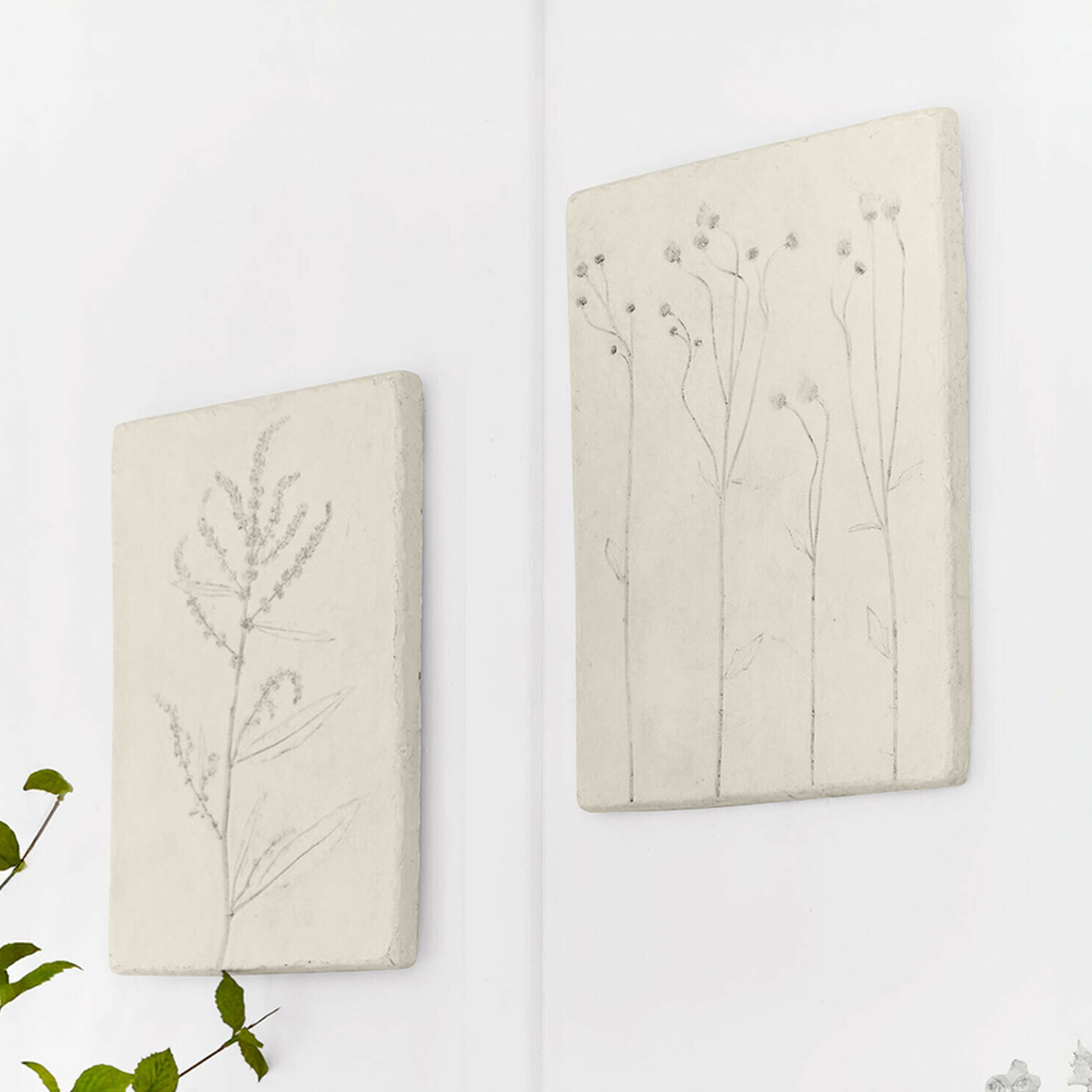 Twee beige wandpanelen met plantenreliëf, gemaakt van natuurlijk materiaal voor wanddecoratie.