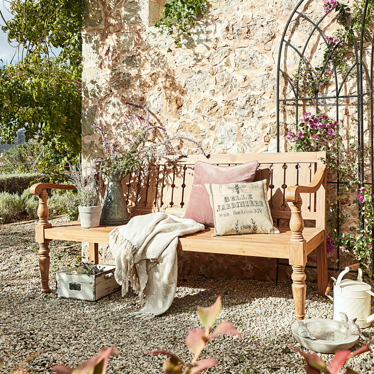 Bank Loudoun Houten tuinbank met kussens en deken op grindterras met planten en decoraties