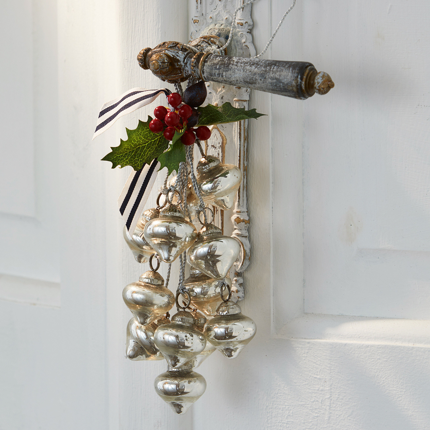Kerstversiering Sassey Kerstdecoratie van zilverkleurig glas met rode bessen aan witte deur gehangen
