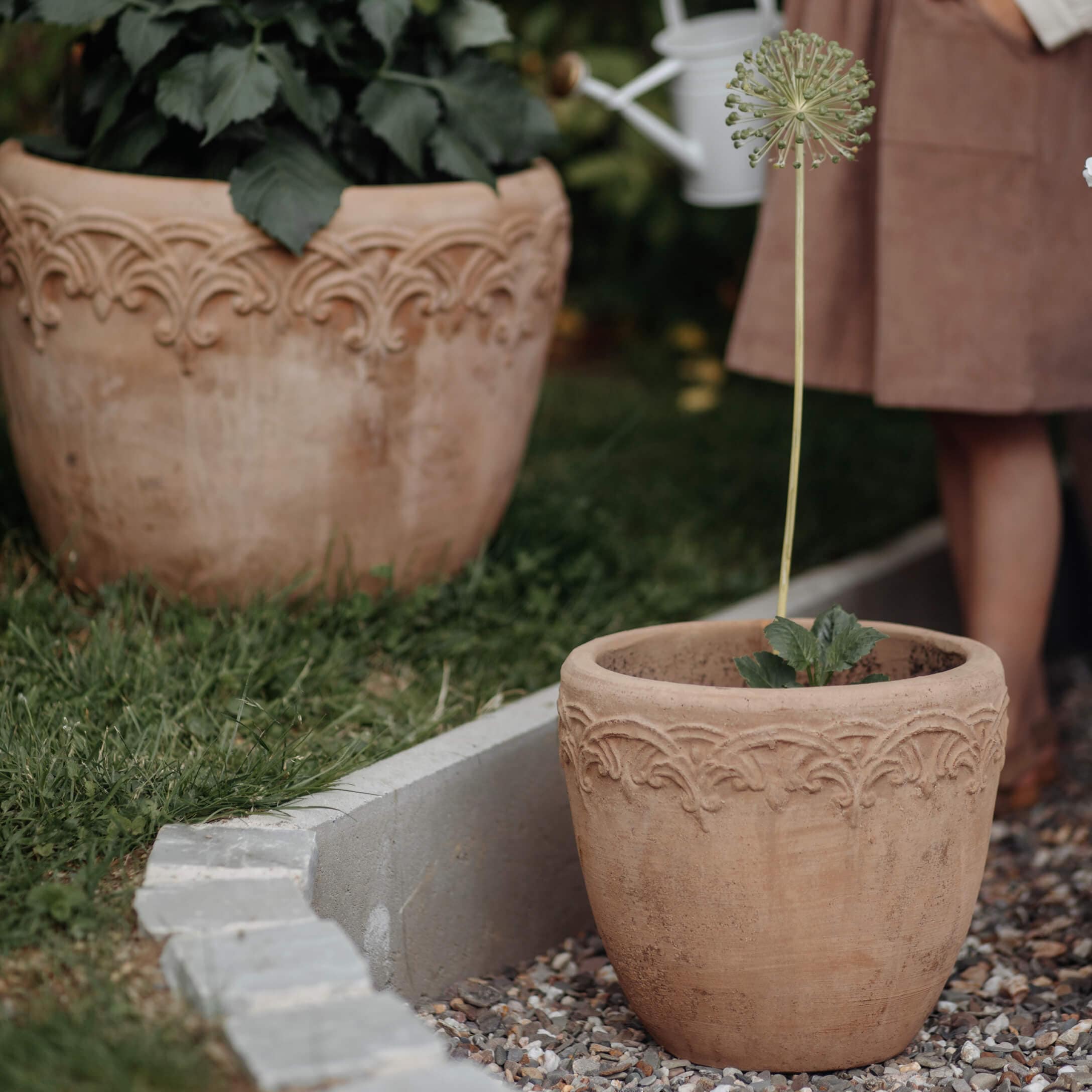 Terracotta bloempot met decoratief patroon in natuurlijke beige kleur in tuin