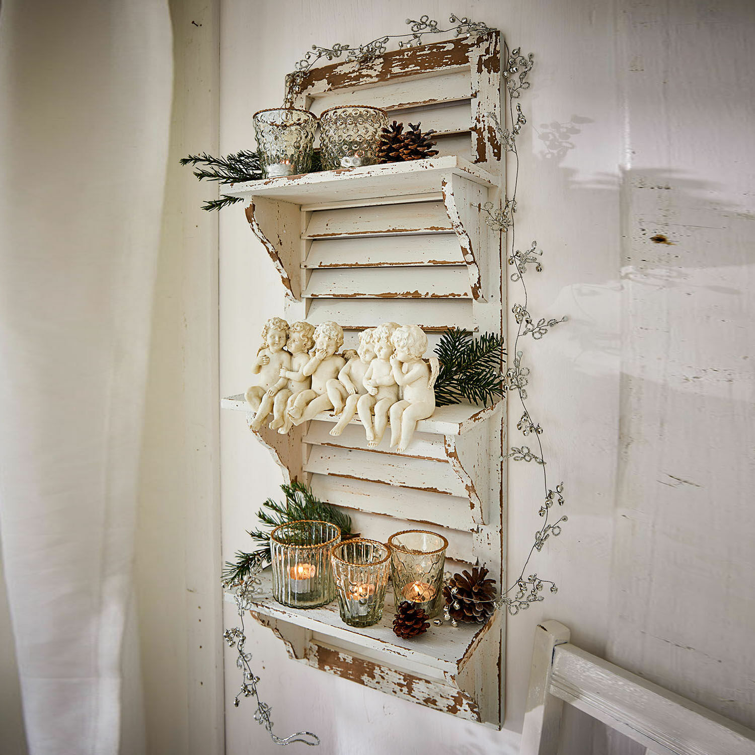 Rustiek wit houten wandrek met engelfiguurtjes en theelichthouders voor feestelijke decoratie