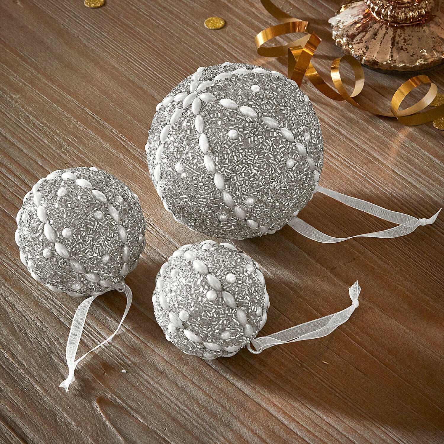 Kerstbal set van 3 Maelvik Set van drie zilveren kerstballen met kralen en linten op houten tafel