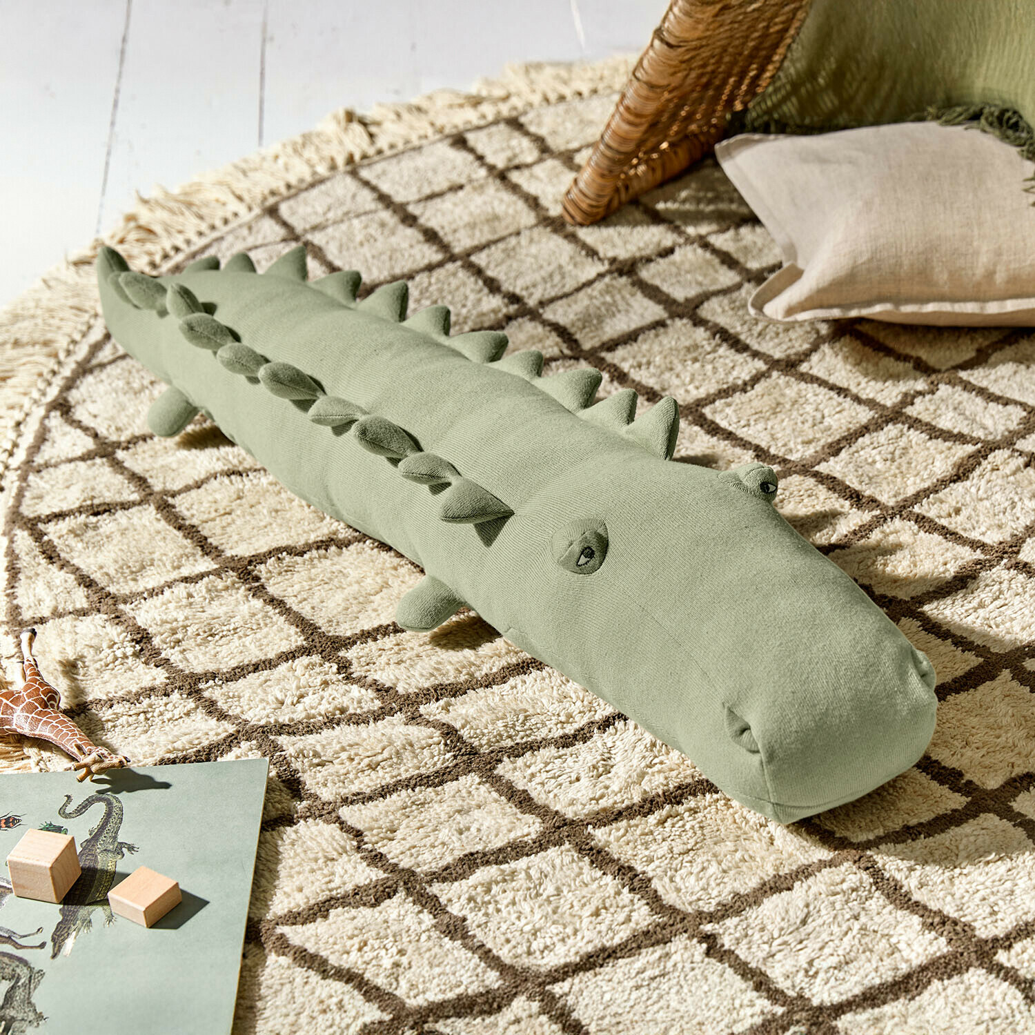 Knuffeltje Zimpy Zachte groene krokodillenknuffel op een beige tapijt met geometrisch patroon