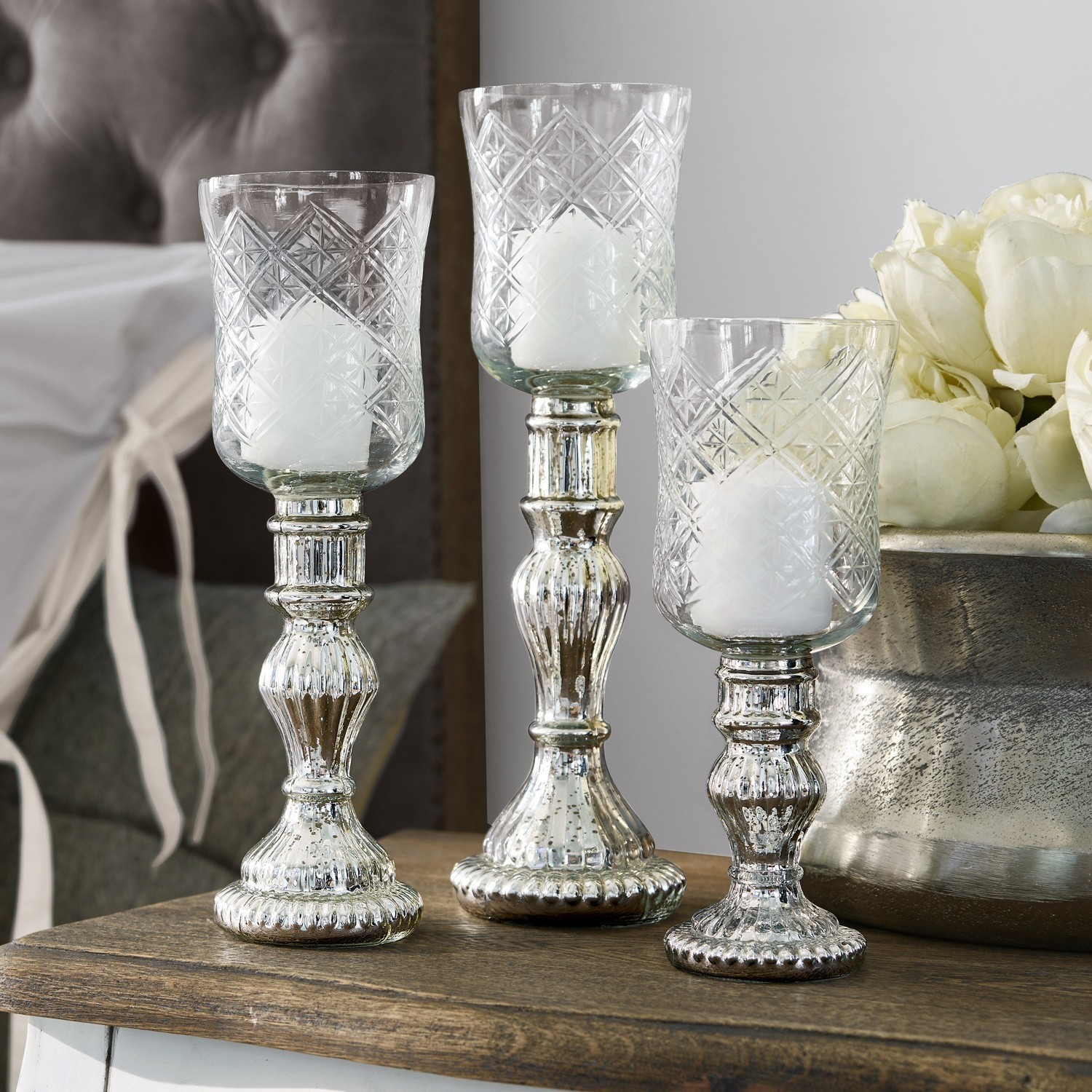Windlicht set van 3 Celestin Set van drie glazen kandelaren met zilverkleurige metalen voet op houten tafel