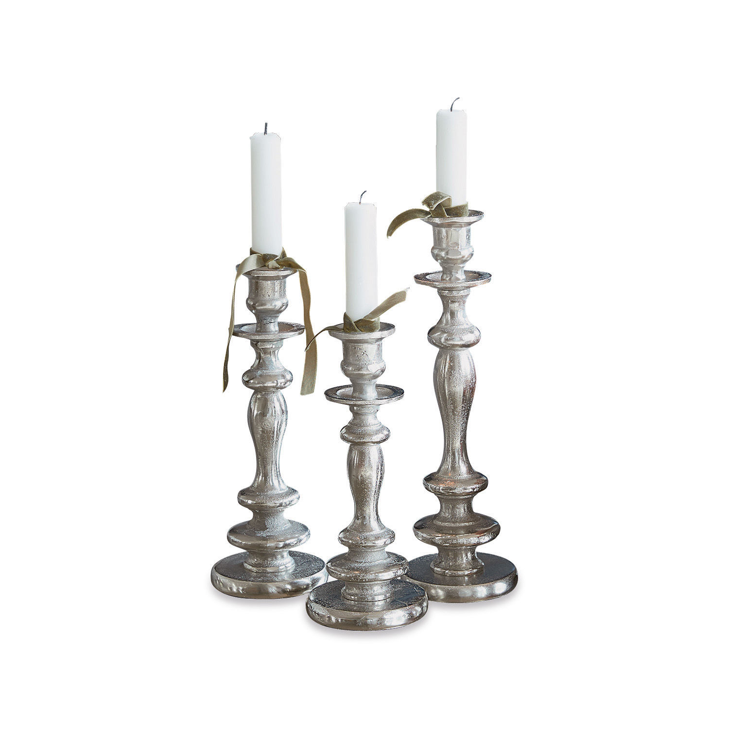 Set van drie zilverkleurige metalen kandelaars met witte kaarsen en decoratieve linten