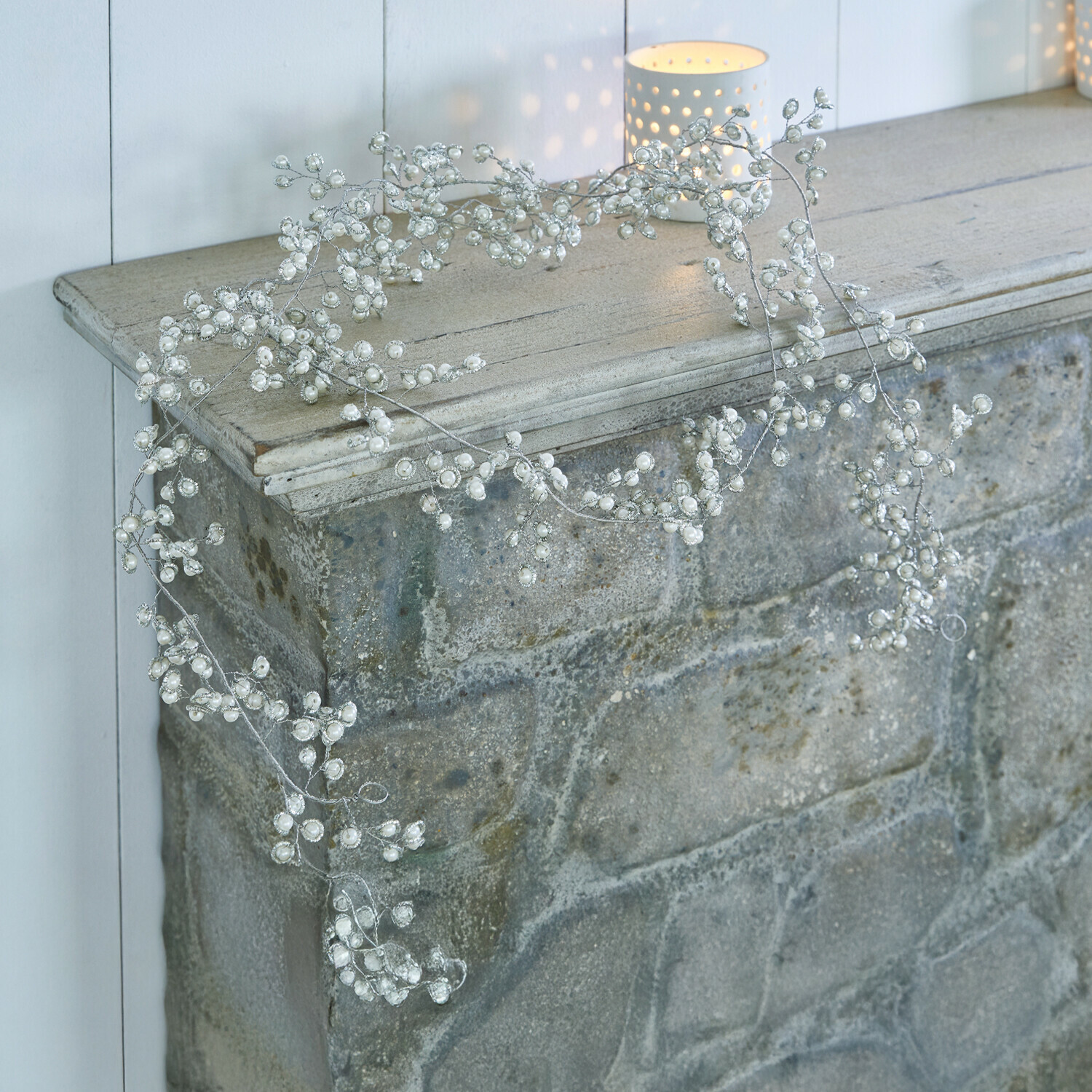 Delicate decoratieve krans met witte parels op zilveren draad, versiering voor open haard of plank