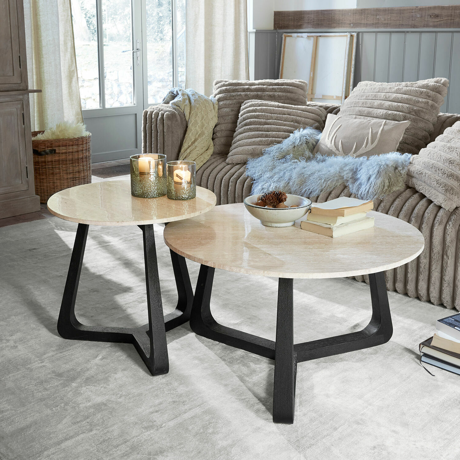 Salontafel set van 2 Tressane Set van twee salontafels met licht marmeren blad en zwarte houten poten in een gezellige woonkamer