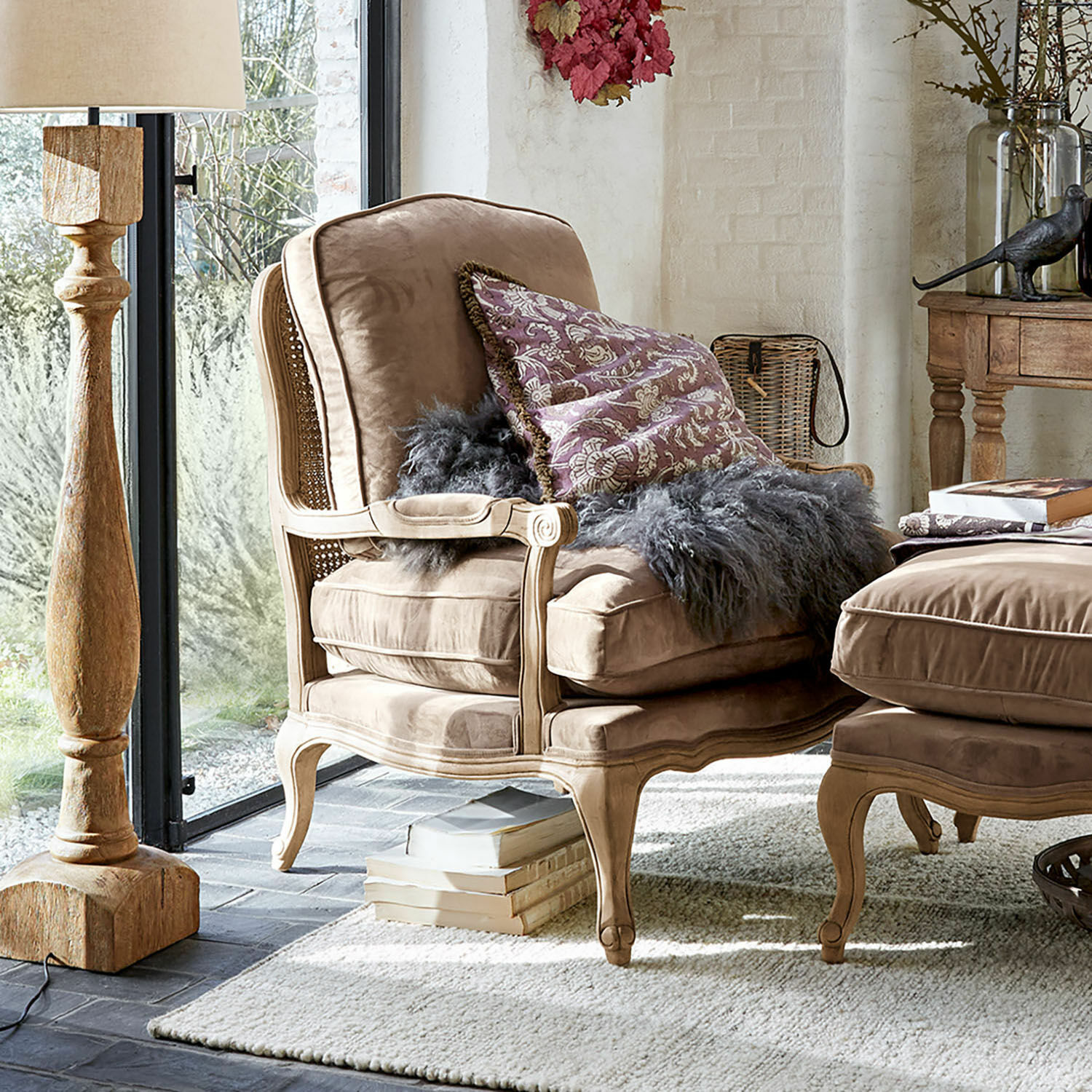 Fauteuil Corlay Beige fluwelen fauteuil met houten frame en decoratief kussen in lichte woonkamer
