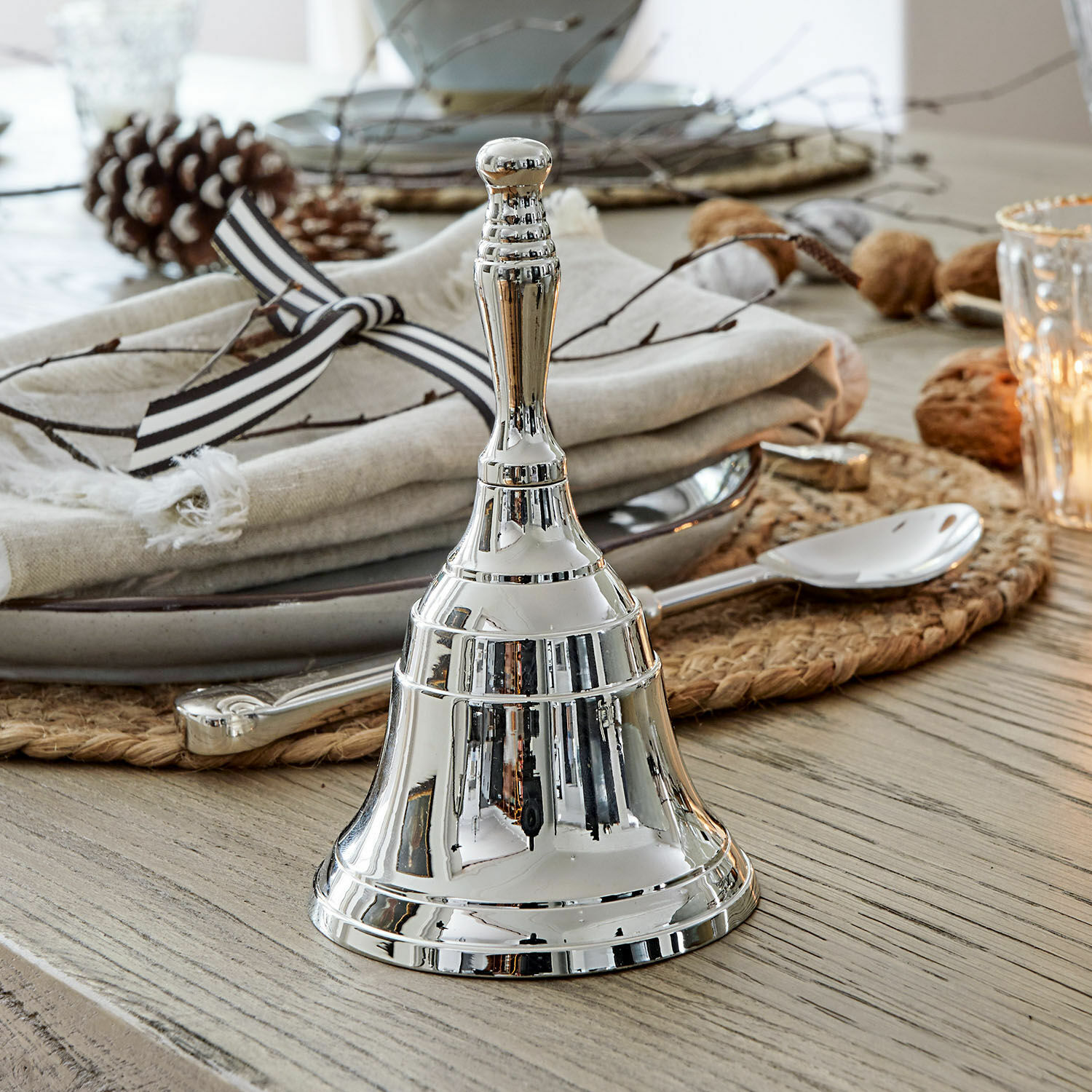 Bel Baron Zilveren metalen tafelbel op houten tafel met decoratie en bestek