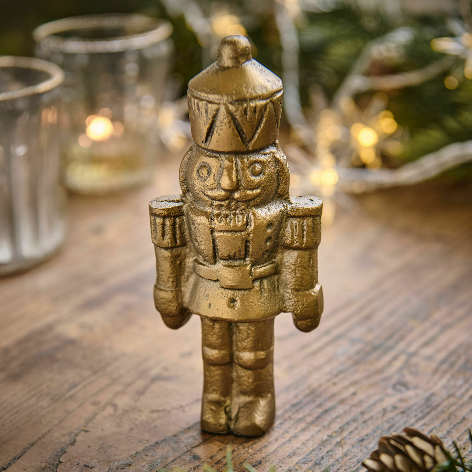 Beeldje Zarilith Gouden metalen notenkrakerfiguur op houten tafel, kerstdecoratie