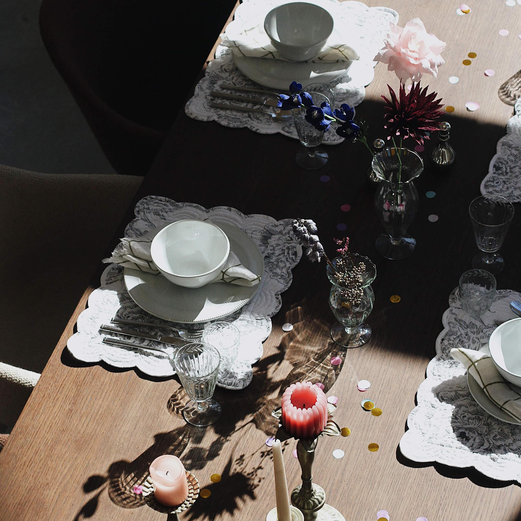 Elegant gedekte tafel met wit servies, glazen en kaarsen op houten blad