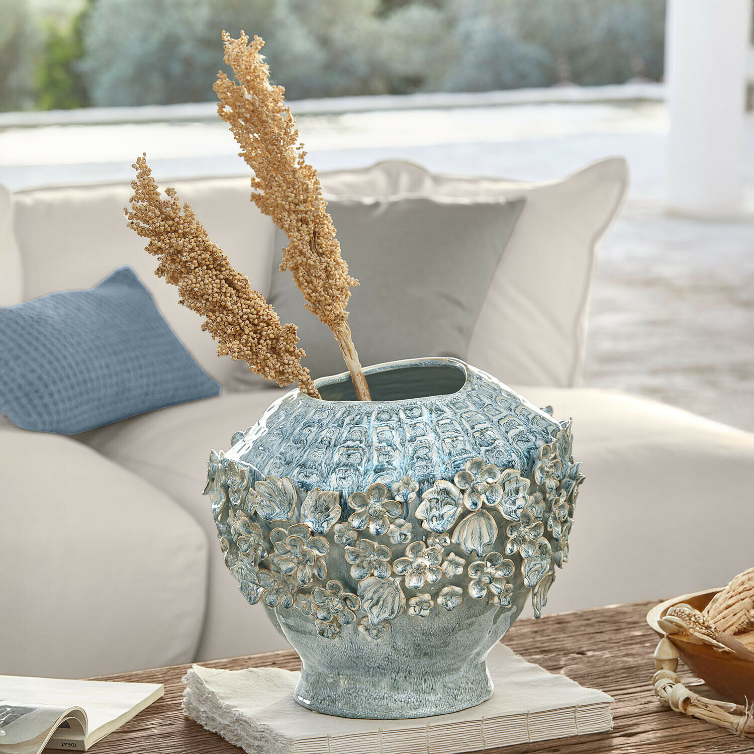 Vaas Mireauxine Decoratieve blauwe keramische vaas met bloemenreliëf op houten tafel in lichte woonkamer