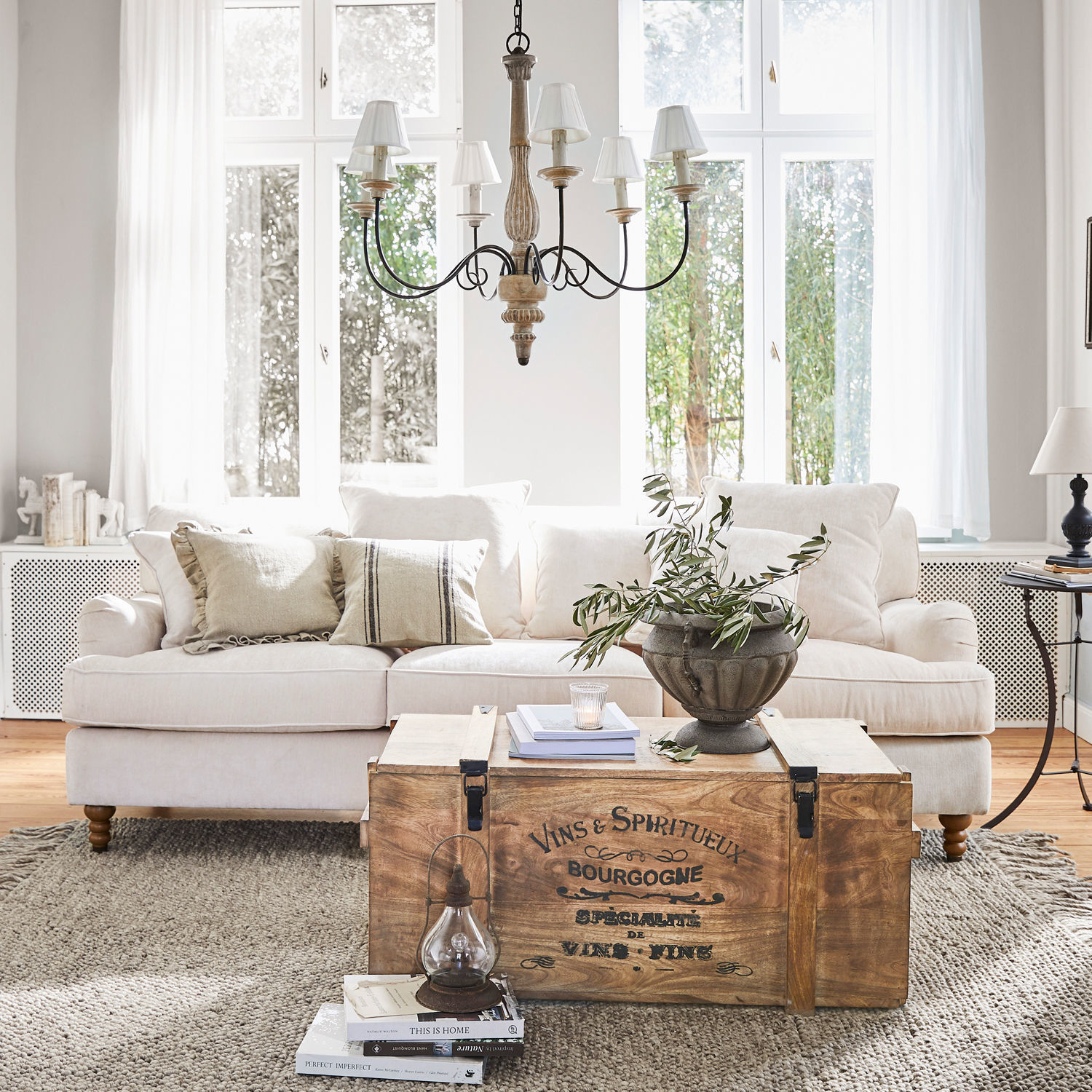 Houten kist met vintage tekst als salontafel in lichte woonkamer met beige bank en decoratie
