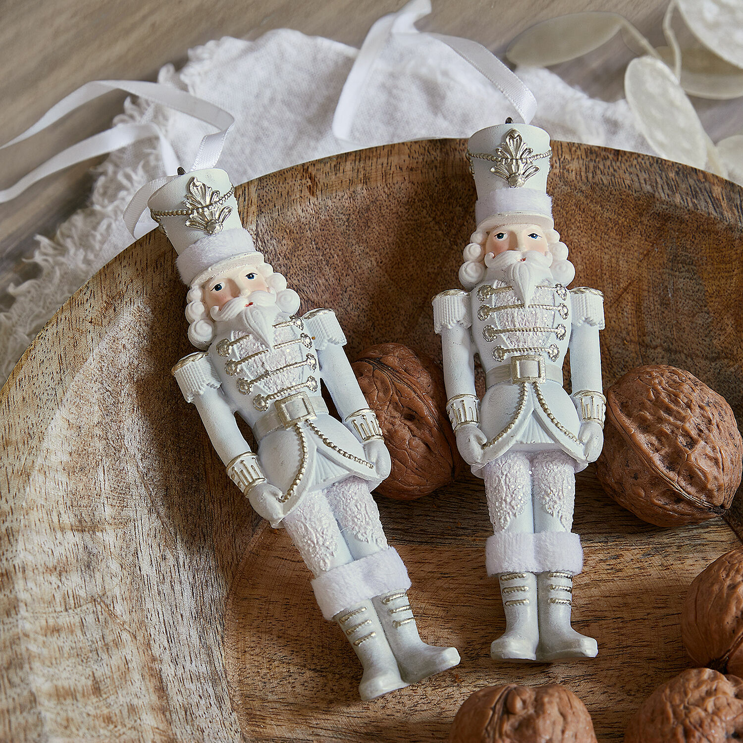Hanger set van 2 Moriette Twee witte decoratieve soldaatfiguren van materiaal met linten op houten schaal met walnoten