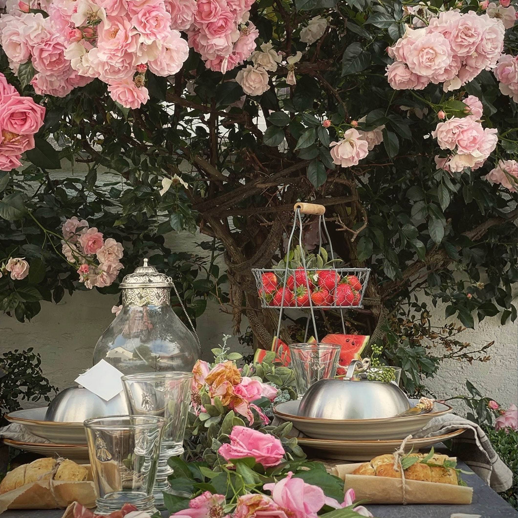 Tuin tafel met rozen en vers fruit, ideaal voor zomerse buitenmaaltijden