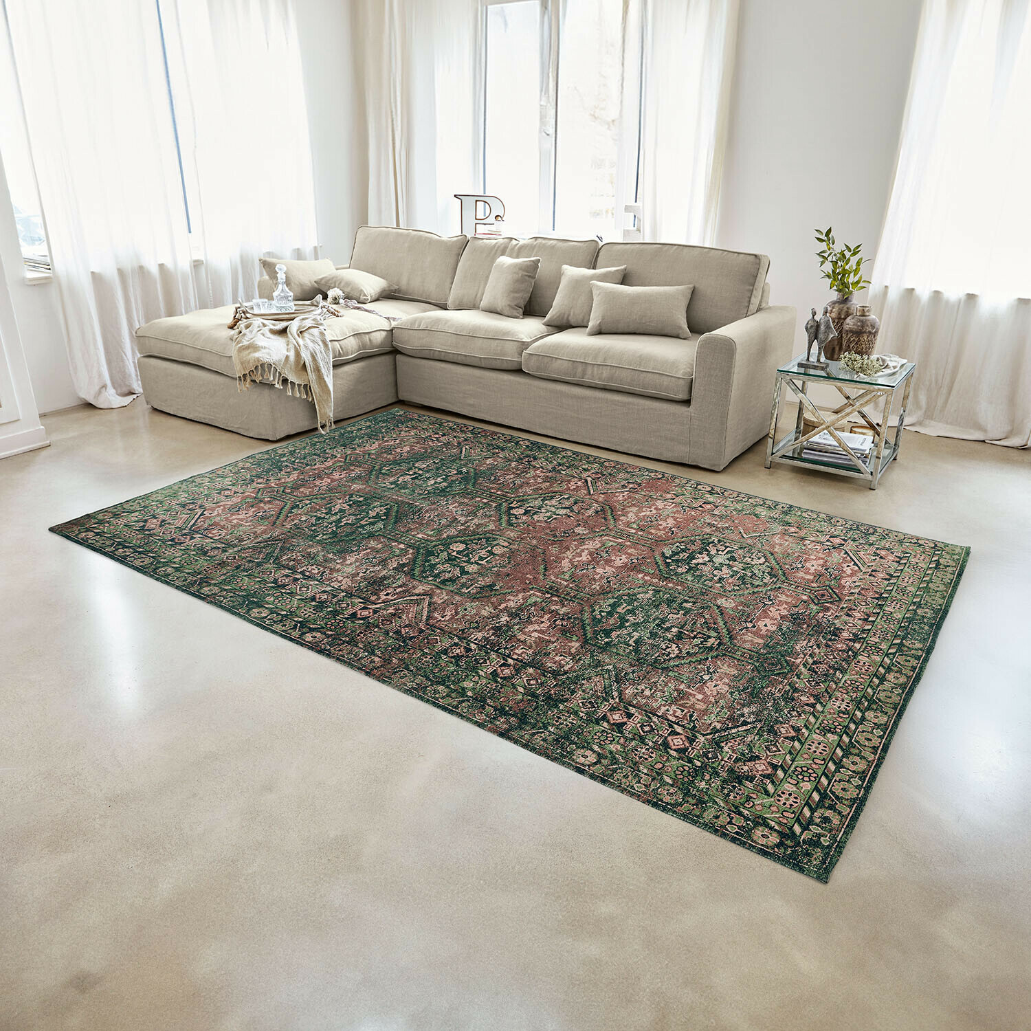 Oosterse vloerkleed in groen-roze tinten op lichte vloer in moderne woonkamer met bank