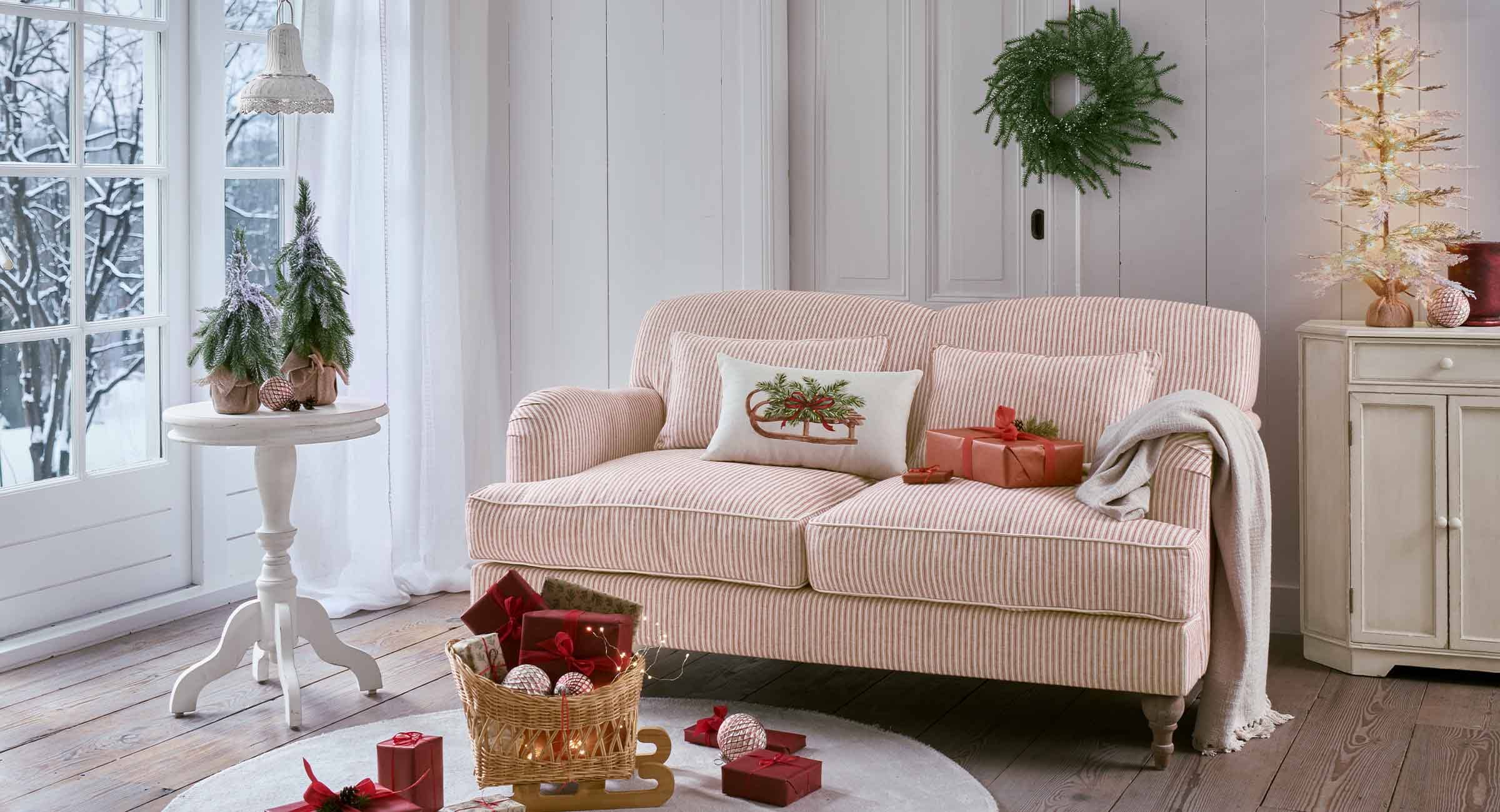 Rood-wit gestreepte bank met decoratief kussen en kerstcadeaus in een gezellige woonkamer