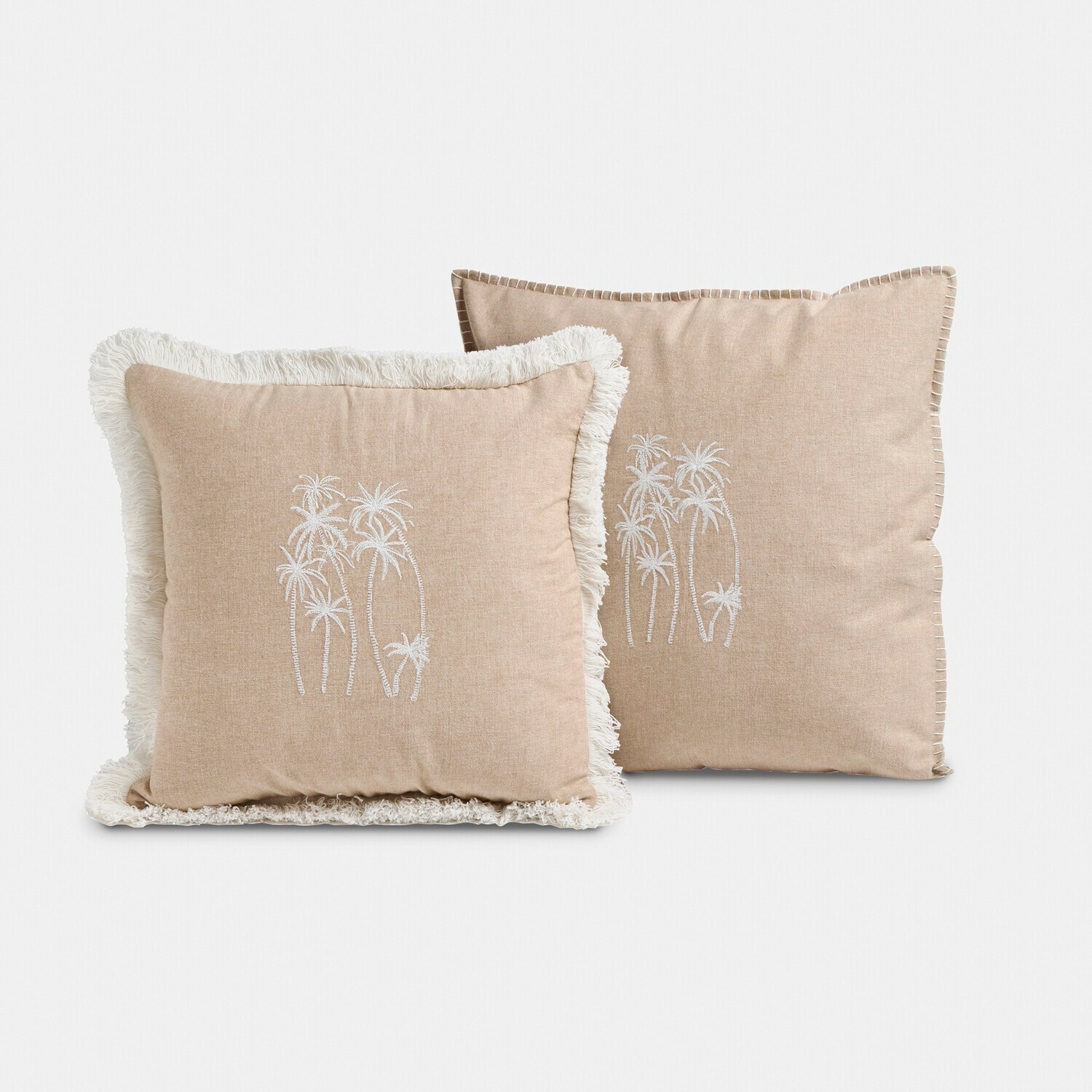 Beige sierkussens van zachte stof met witte palmboom borduursels en franjes