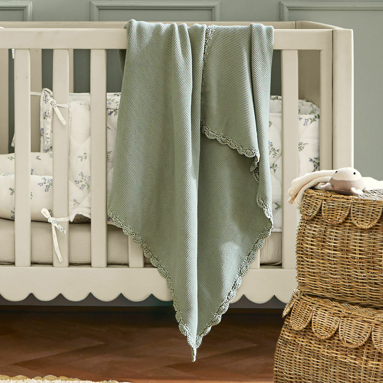 Plaid Nymariel Zachte groene katoenen deken met kanten rand op een beige babybed, kinderkamerdecoratie