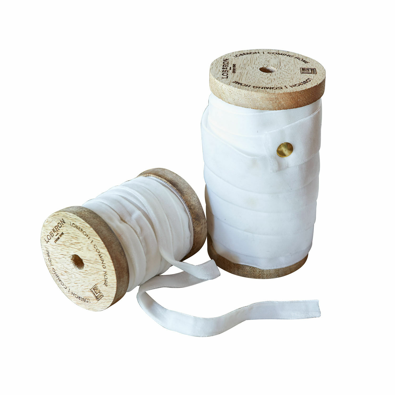 Crèmekleurige fluwelen linten op houten spoelen voor decoratie en knutselen