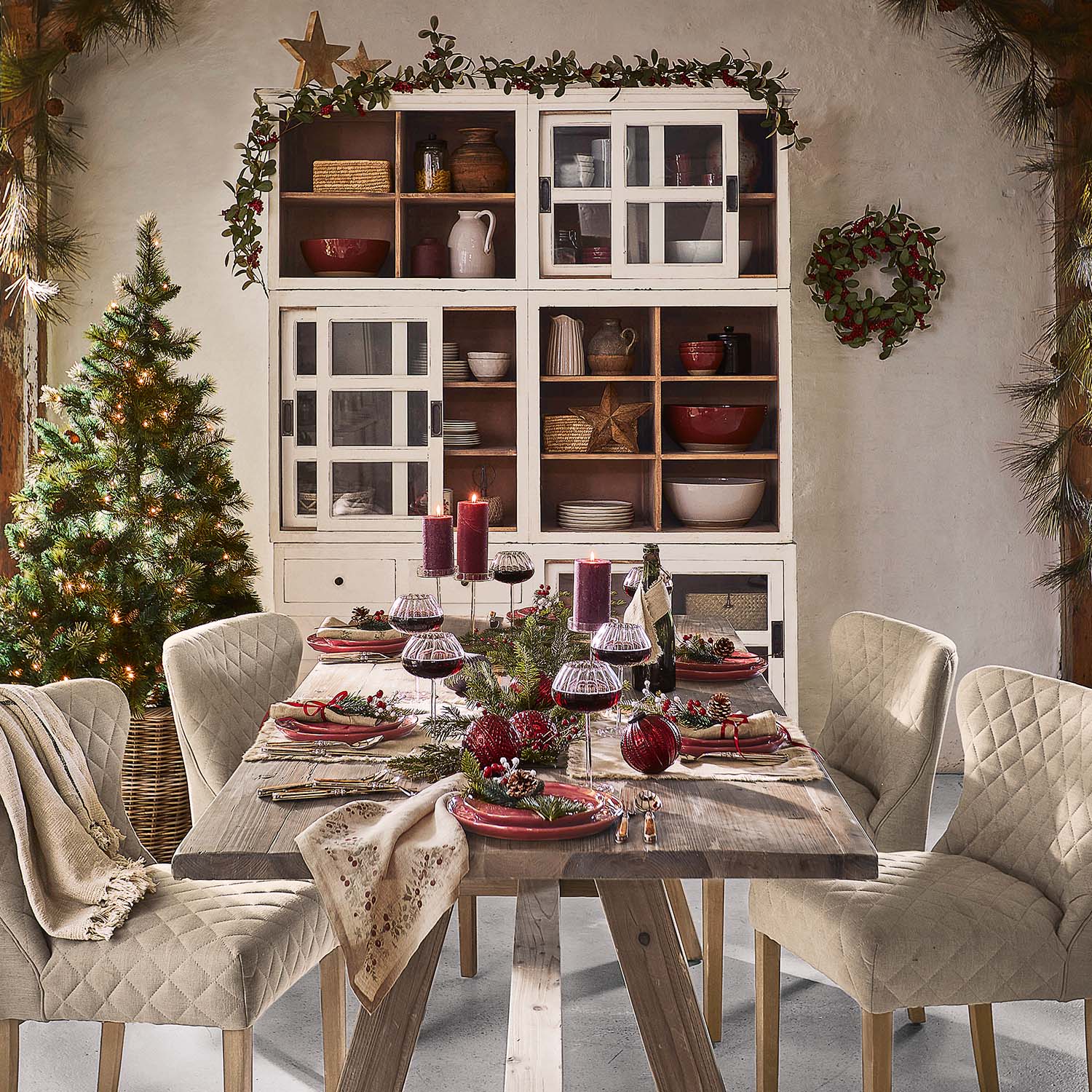 Rustieke houten tafel met beige gewatteerde stoelen en kerstdecoratie in eetkamer