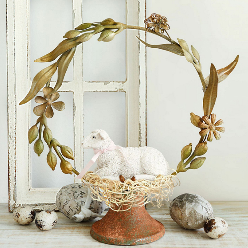 Decoratief lammetjesbeeld op rustieke standaard met metalen krans en decoratieve eieren