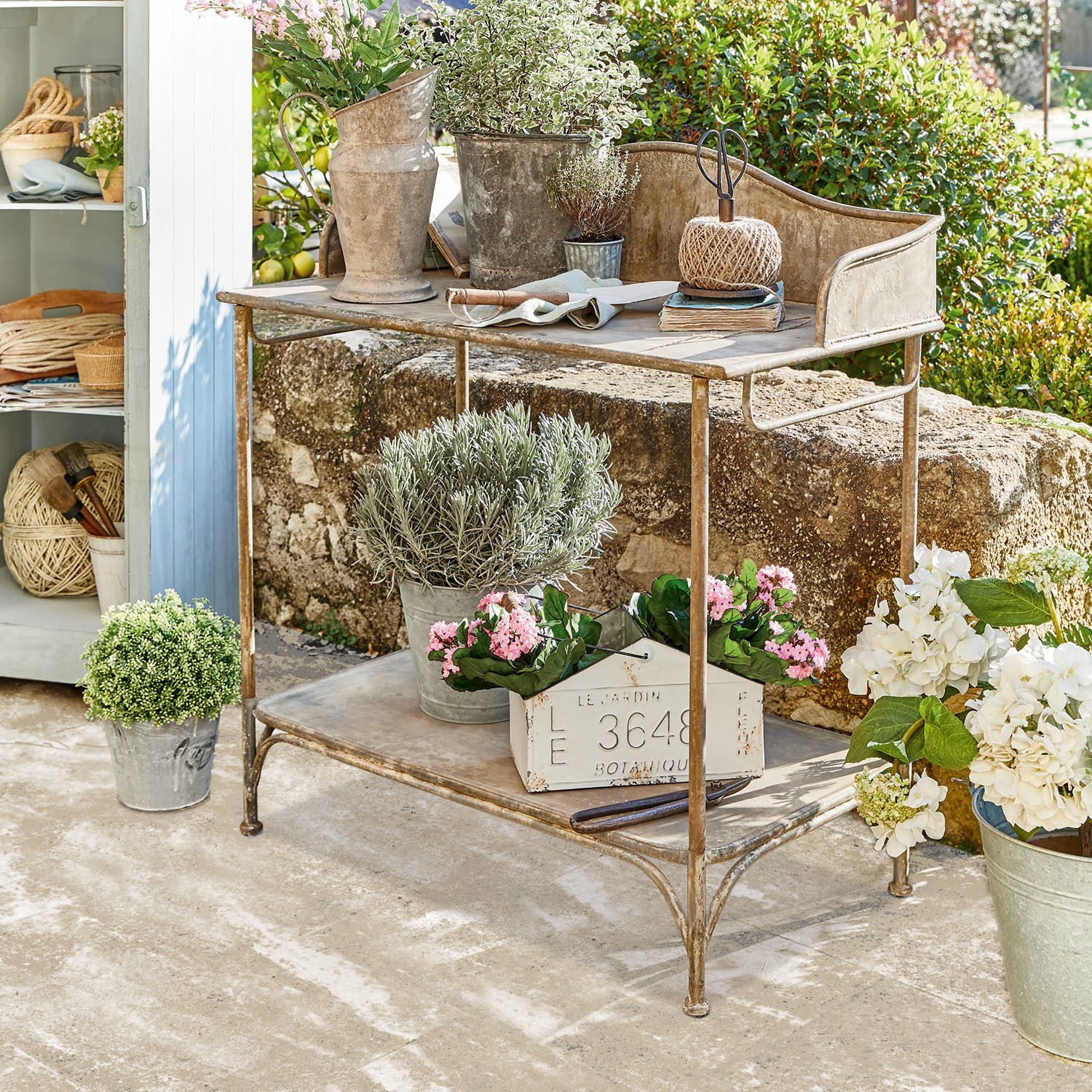 Plantentafel Banners Metalen tuintafel met planten en tuingereedschap op zonnig terras