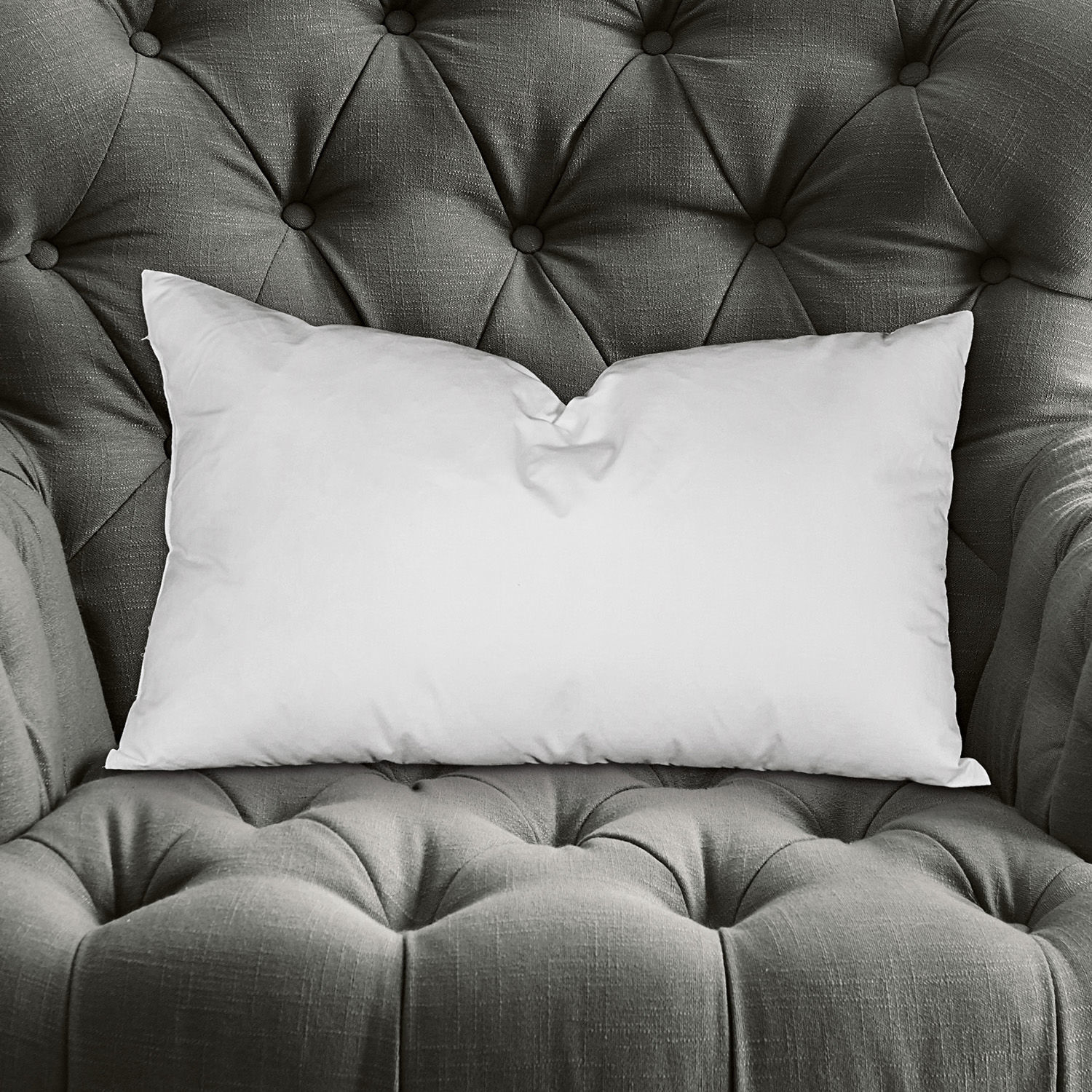 Kussenvulling Indra Witte rechthoekige kussen op grijze gestikte stoffen fauteuil, decoratief en comfortabel