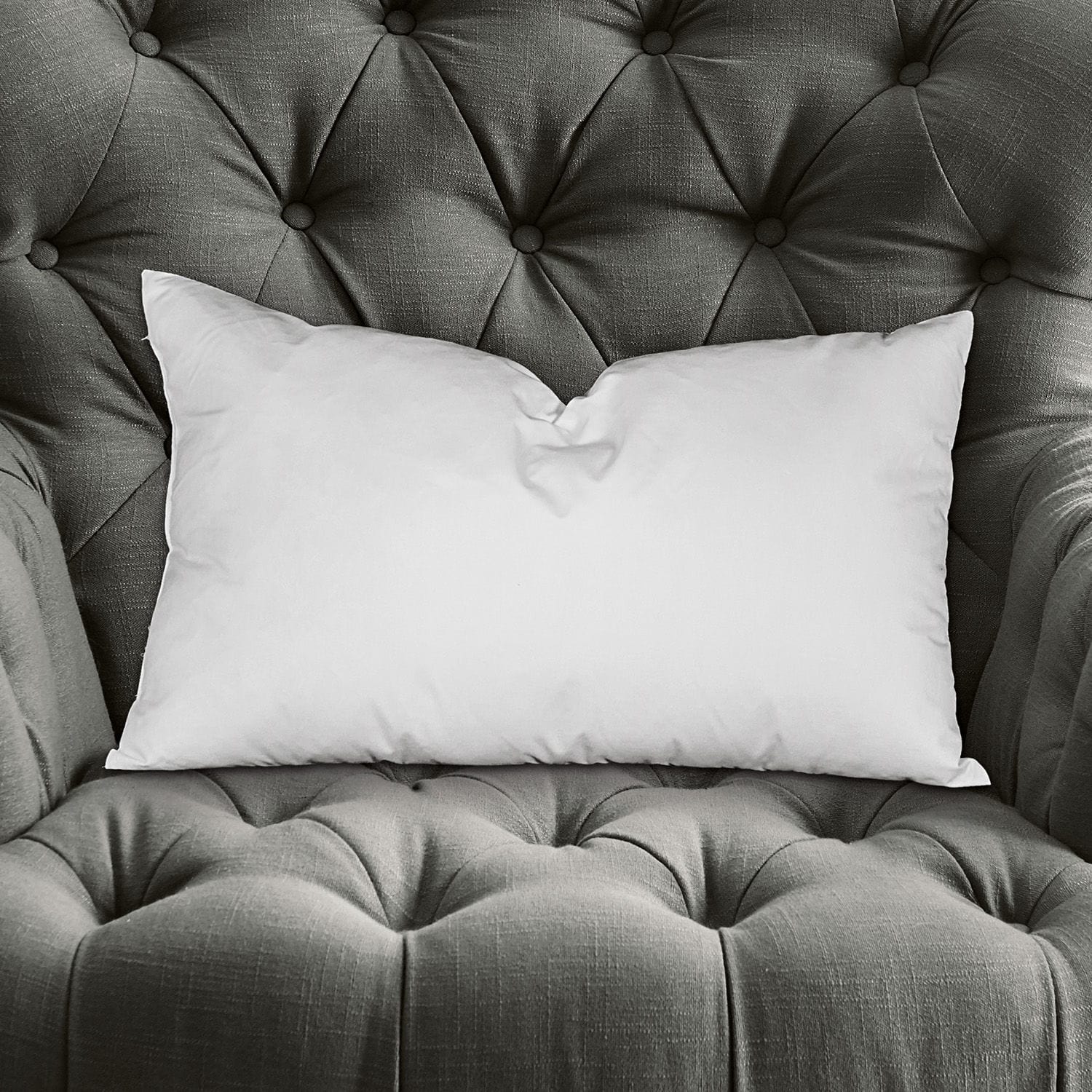 Kussenvulling Indra Witte rechthoekige kussen op grijze gestikte stoffen fauteuil, decoratief en comfortabel