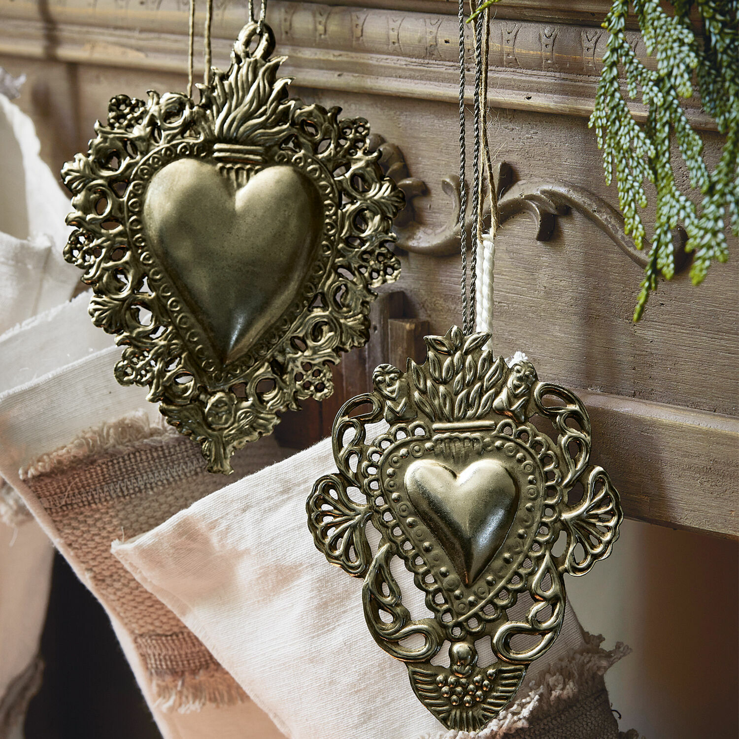 Decoratief ornament set van 2 Medes Decoratieve metalen hartvormige hangers in antiek goudkleur op stof en hout achtergrond