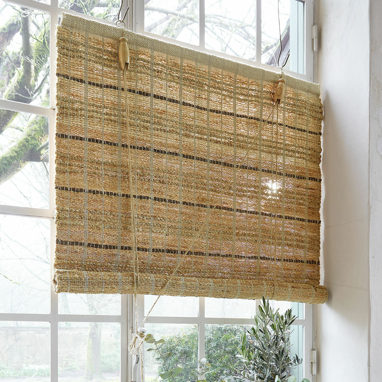 Natuurlijke rolgordijn van geweven materiaal in beige, perfect voor raamdecoratie en zonwering