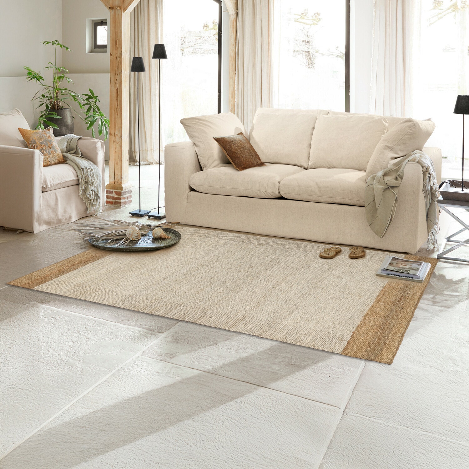 Vloerkleed Estelune Beige vloerkleed van natuurlijk materiaal in lichte woonkamer met bank en fauteuils, decoratief en gezellig