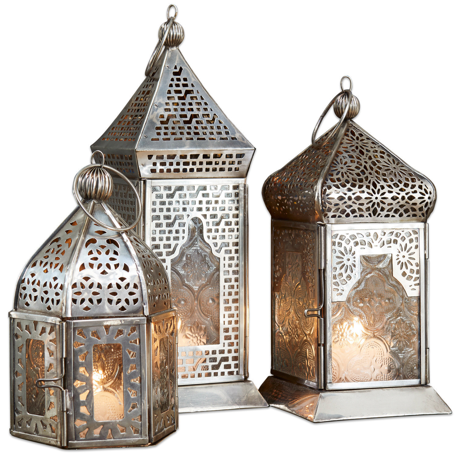 Set van drie zilverkleurige metalen lantaarns met opengewerkt patroon en glazen panelen, interieurdecoratie