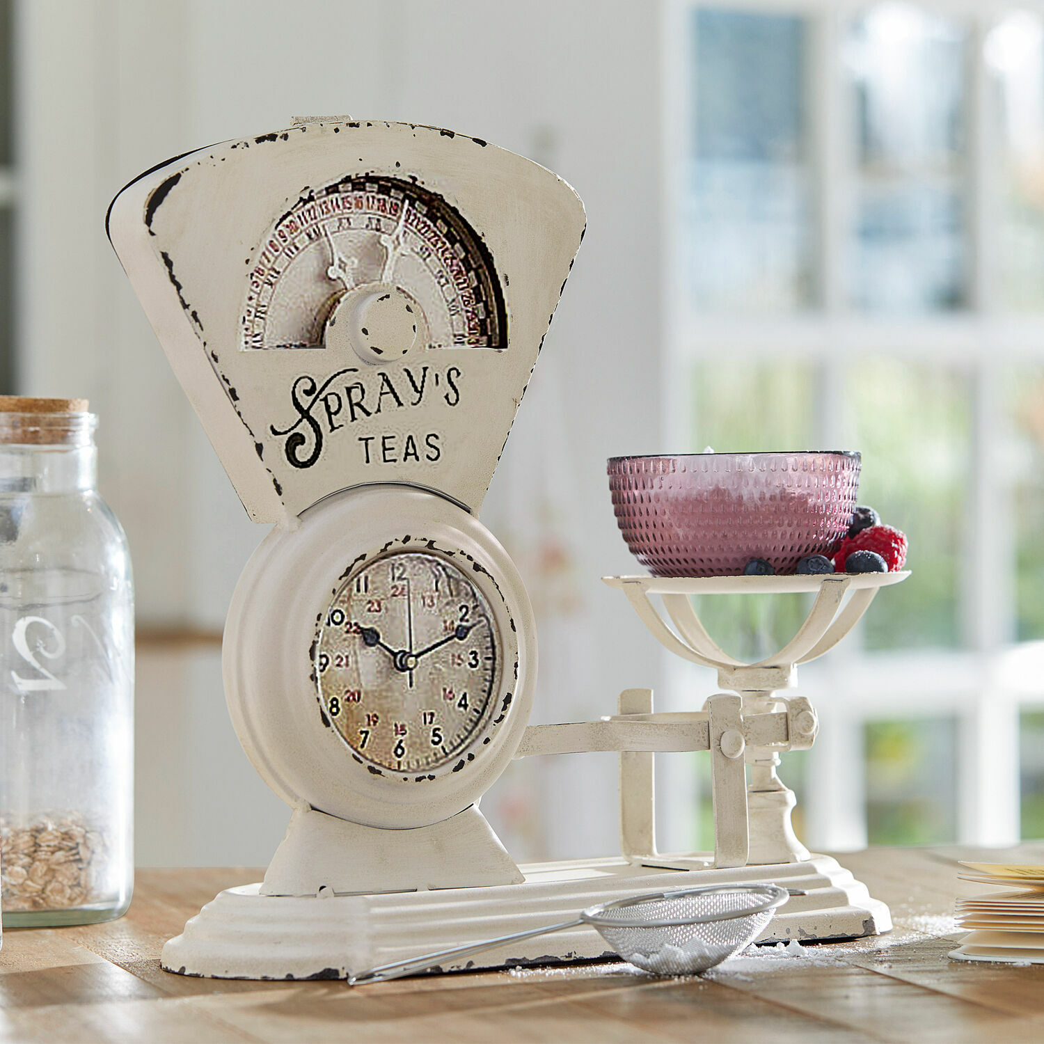 Witte metalen vintage keukenweegschaal met roze kom en vers fruit op houten tafel